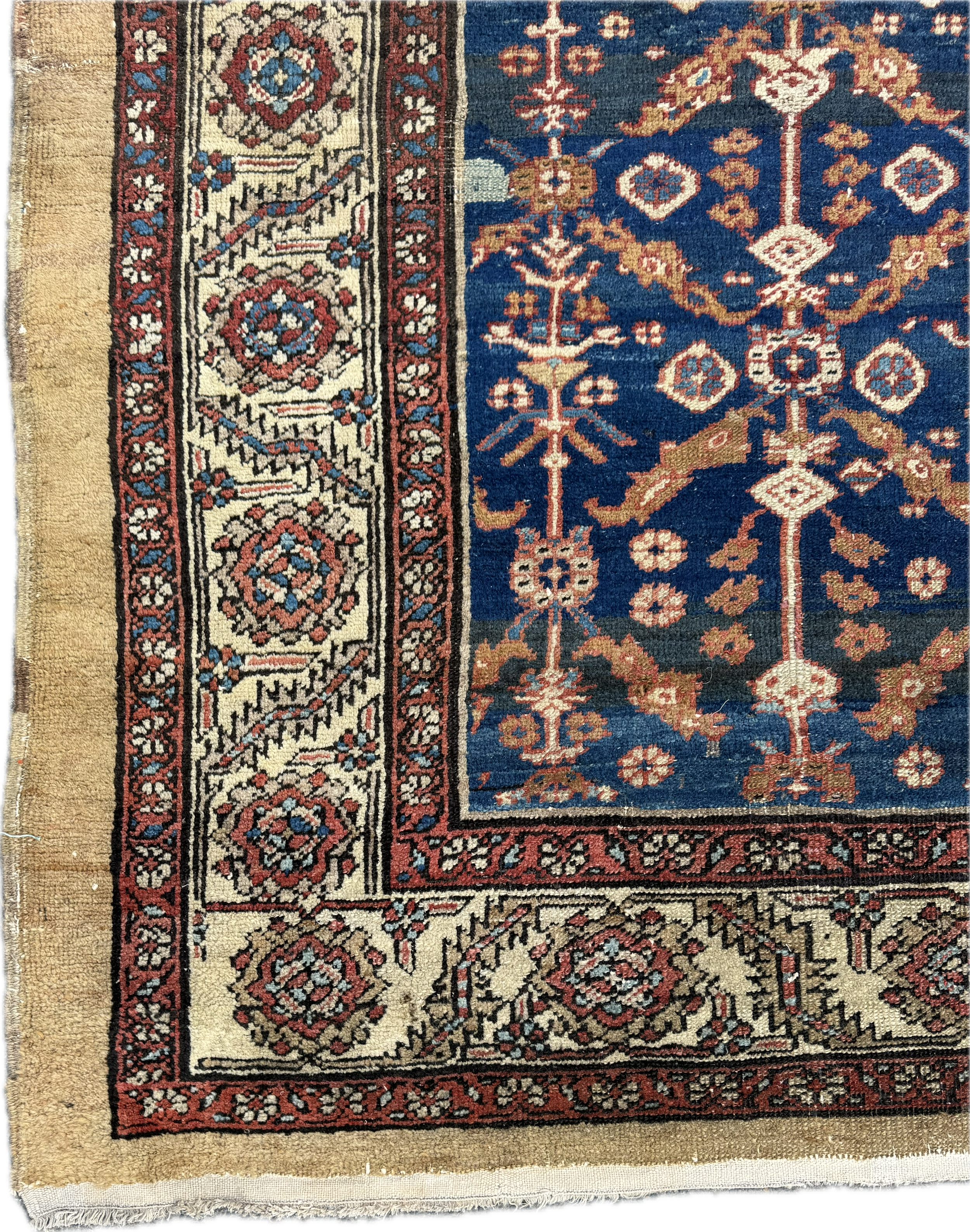 Close-up of a traditional Persian-style rug with intricate floral and geometric patterns in blue, red, beige, and black.