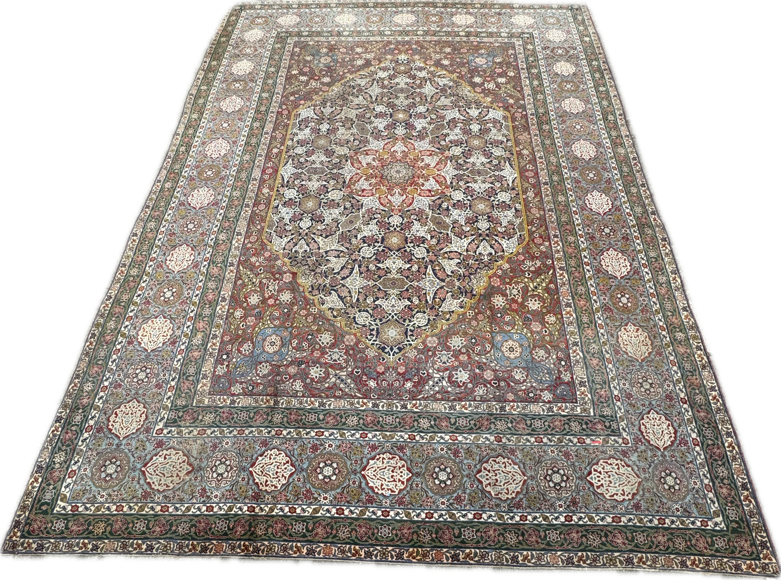 Decorative Persian-style rug with intricate floral designs, multiple borders, and a central medallion in shades of red, cream, blue, and brown.