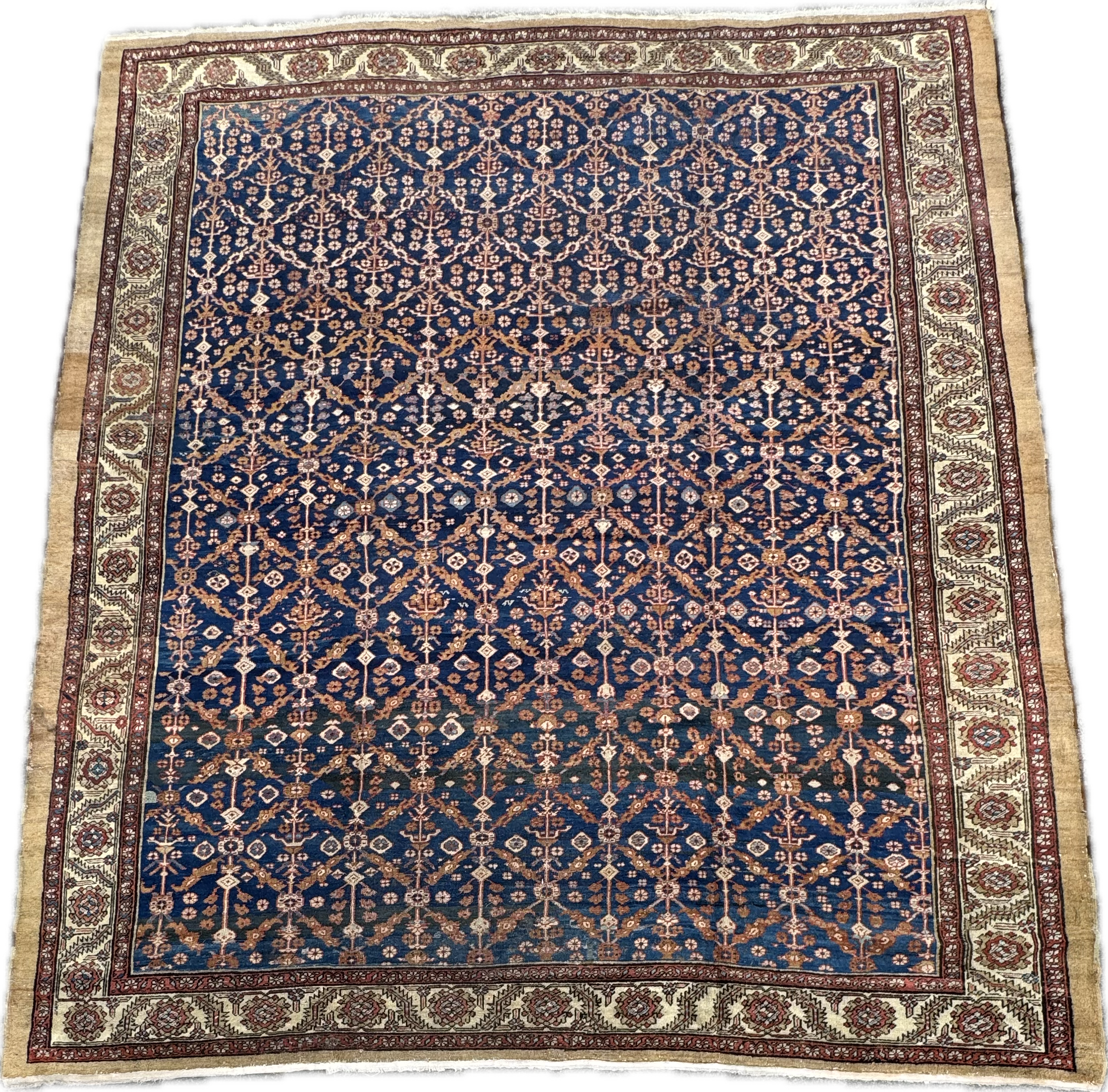 A traditional Persian-style area rug with a dark blue background and intricate floral and geometric patterns in shades of beige, red, and light blue, framed by a decorative border with floral motifs.