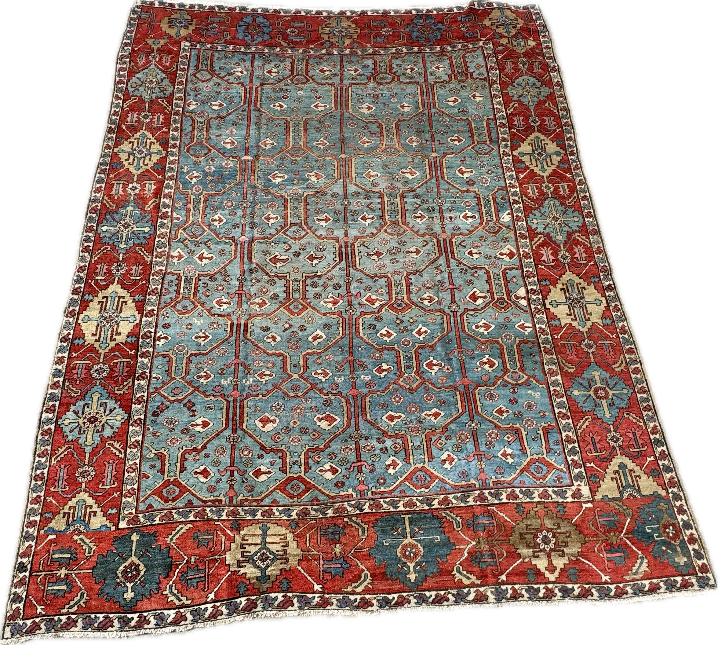 Colorful patterned oriental rug with a red border, blue center, intricate geometric designs, floral motifs, and decorative borders.