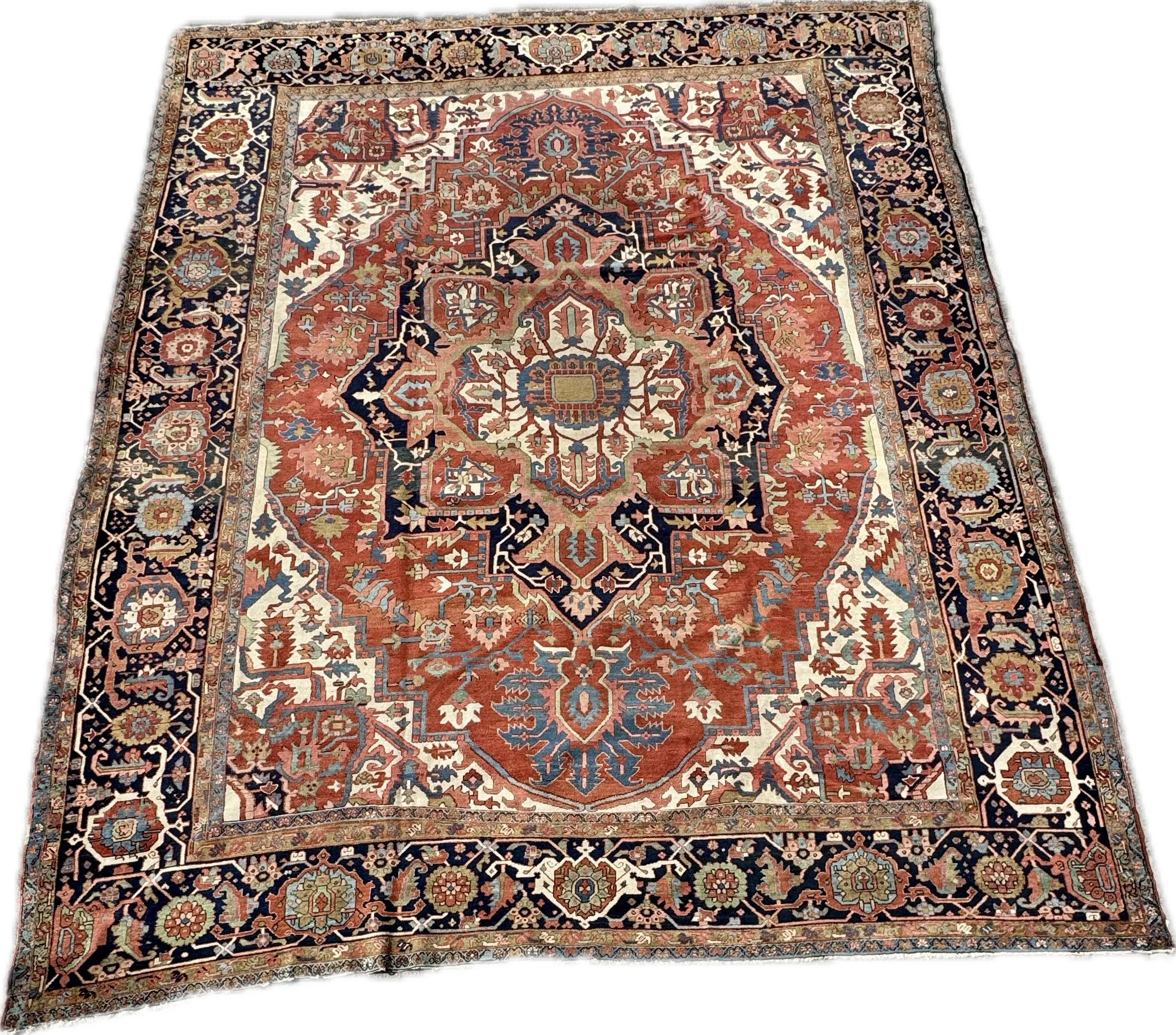 A traditional oriental rug featuring intricate floral and geometric patterns in red, navy blue, beige, and light blue colors.