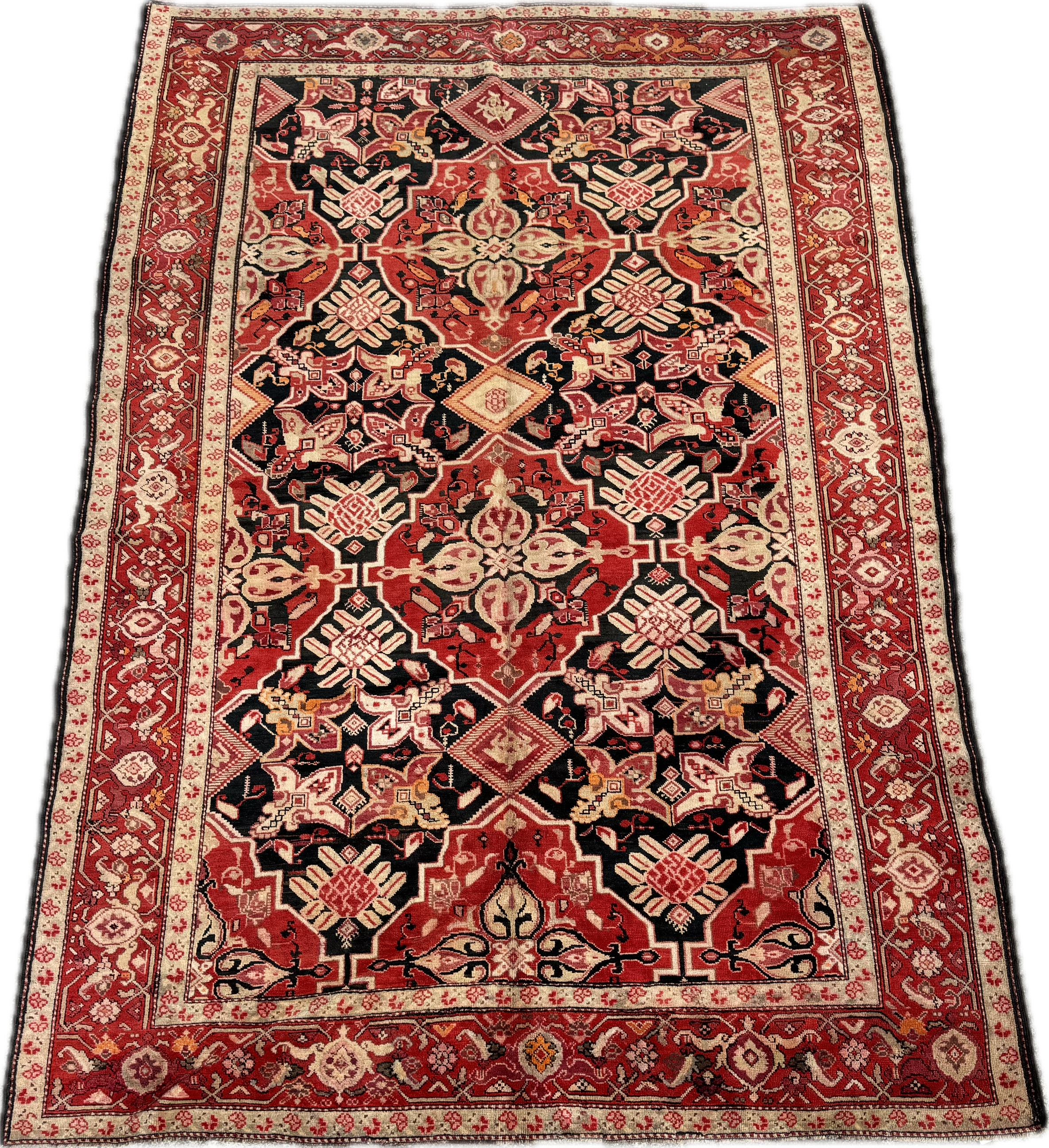 A traditional red, black, cream, and beige patterned Oriental rug with intricate geometric and floral designs.