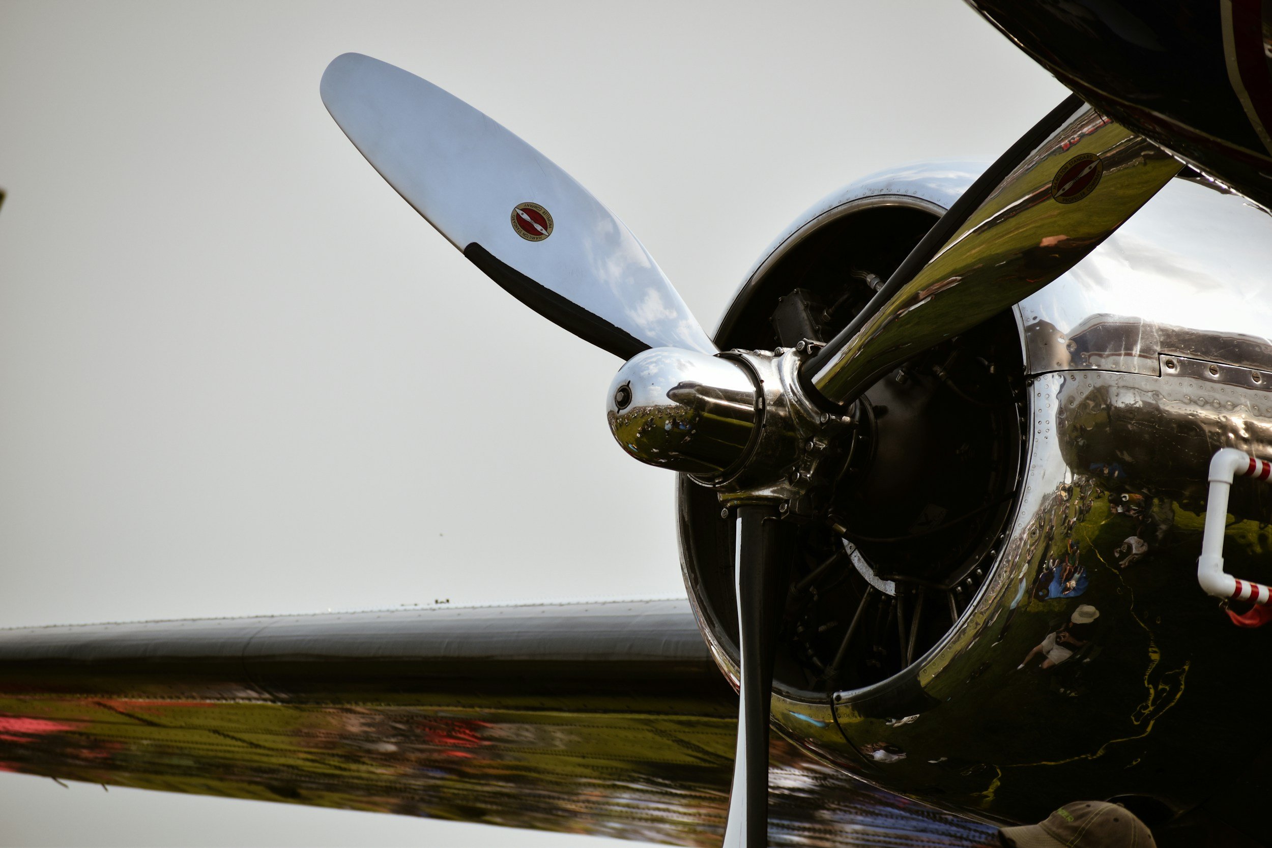 Close-up of a vintage aircraft propeller and engine with shiny metal surface and reflections.