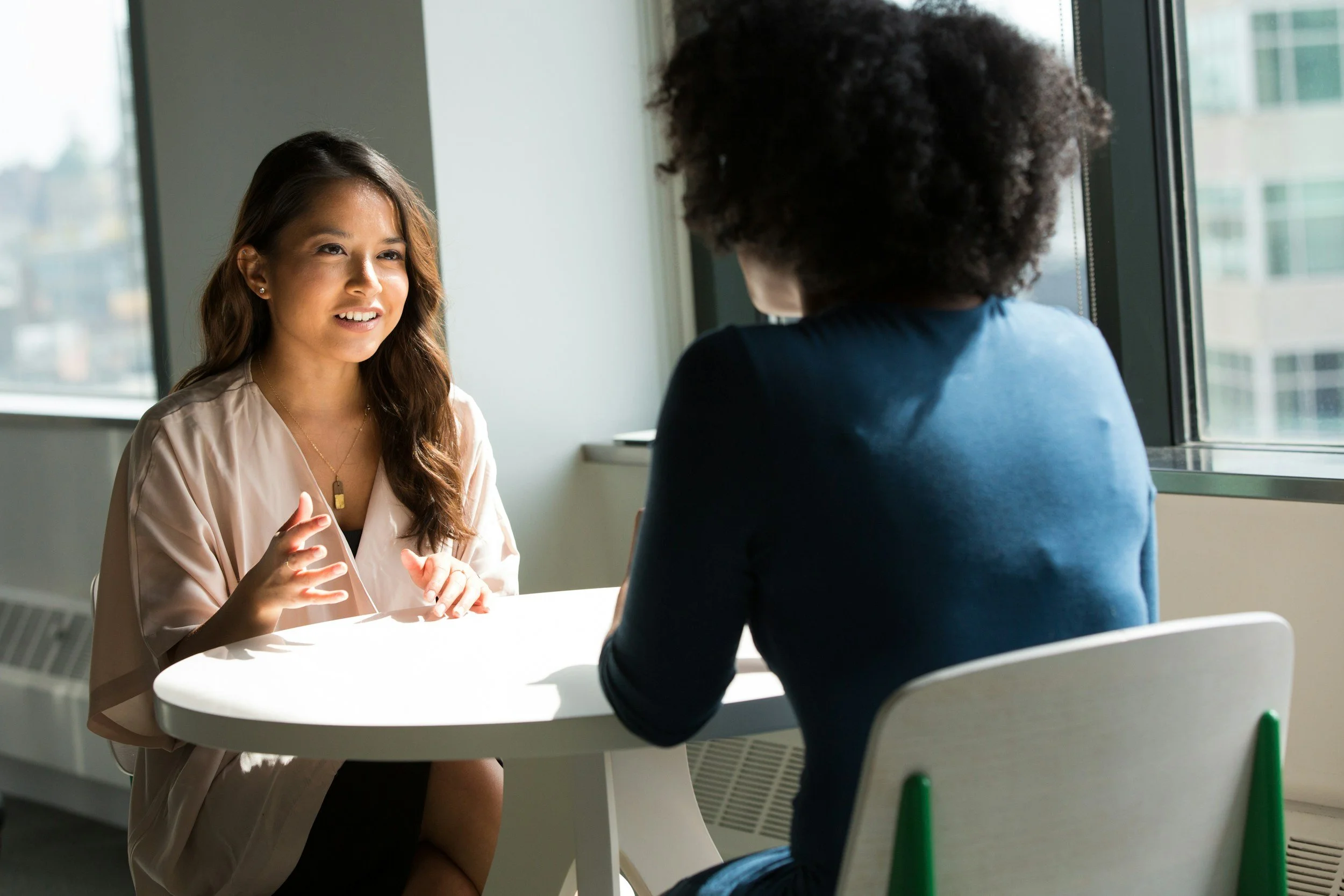 two people talking sitting at a table