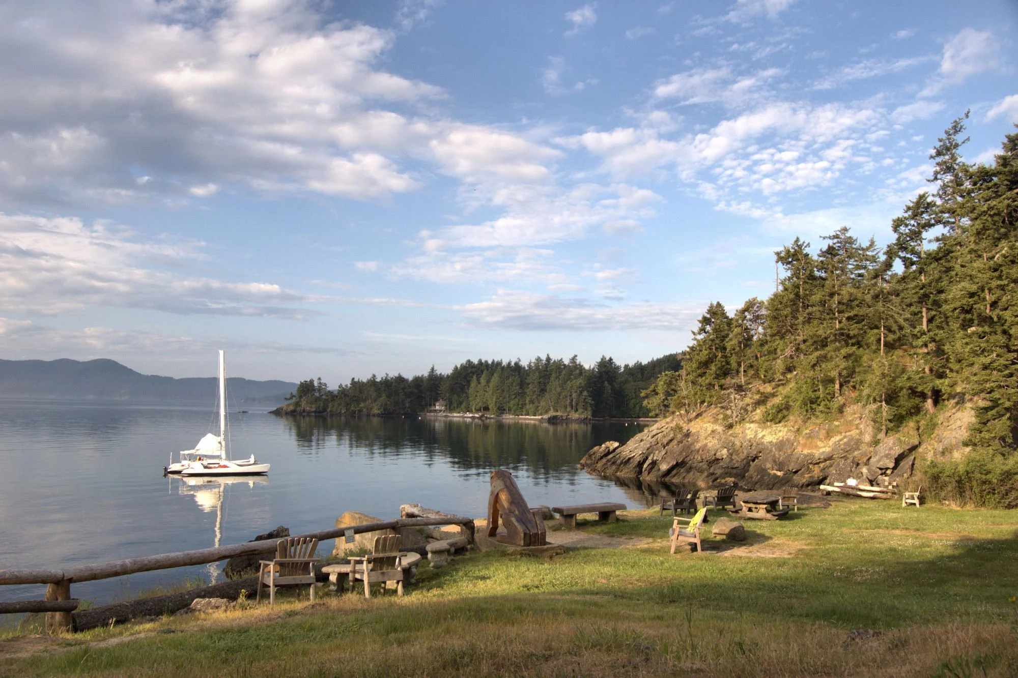 A view of a peaceful puget sound morning with a sailboat in the bay at Doe Bay on Orcas Island.
