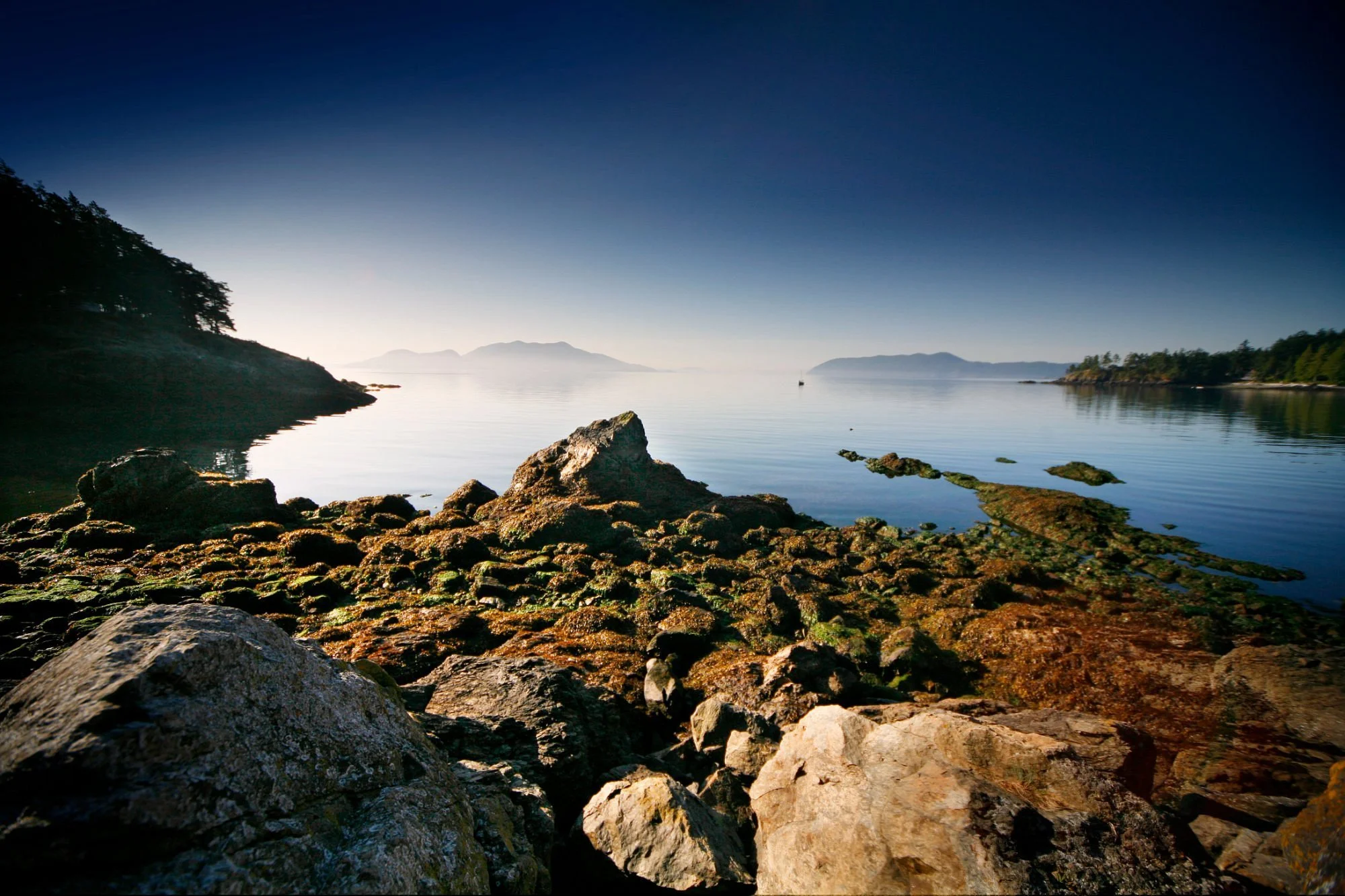 Image of Doe Bay looking over rocks and mountains in the distance.