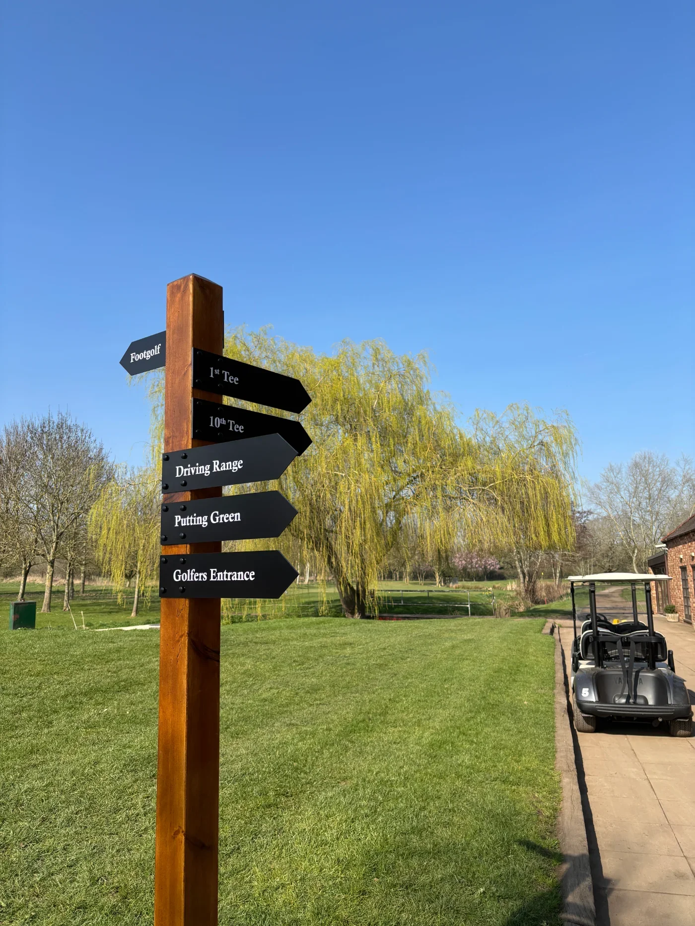 Wooden directional fingerpost sign with black arrows