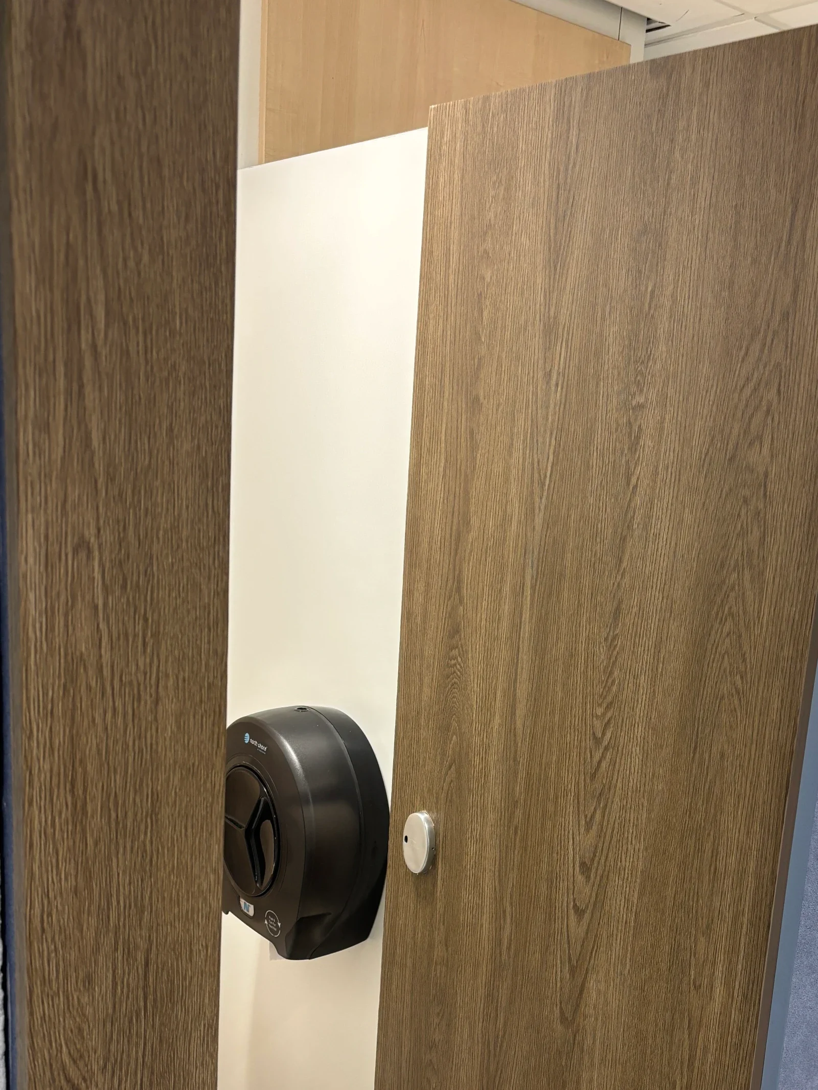 Faux wood grain architectural vinyl installation on bathroom door