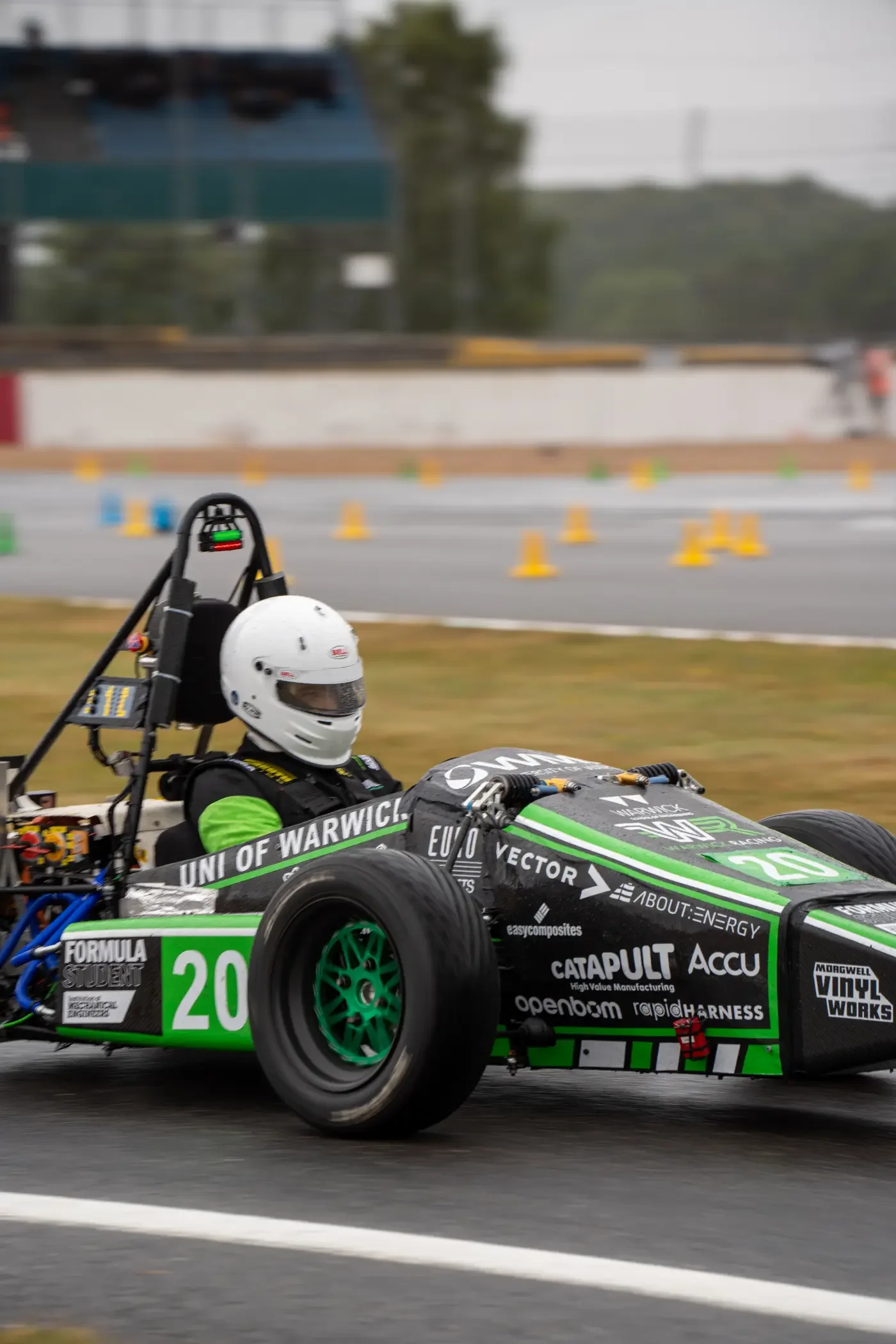 Warwick racing car on track at Silverstone with green wrapped livery 