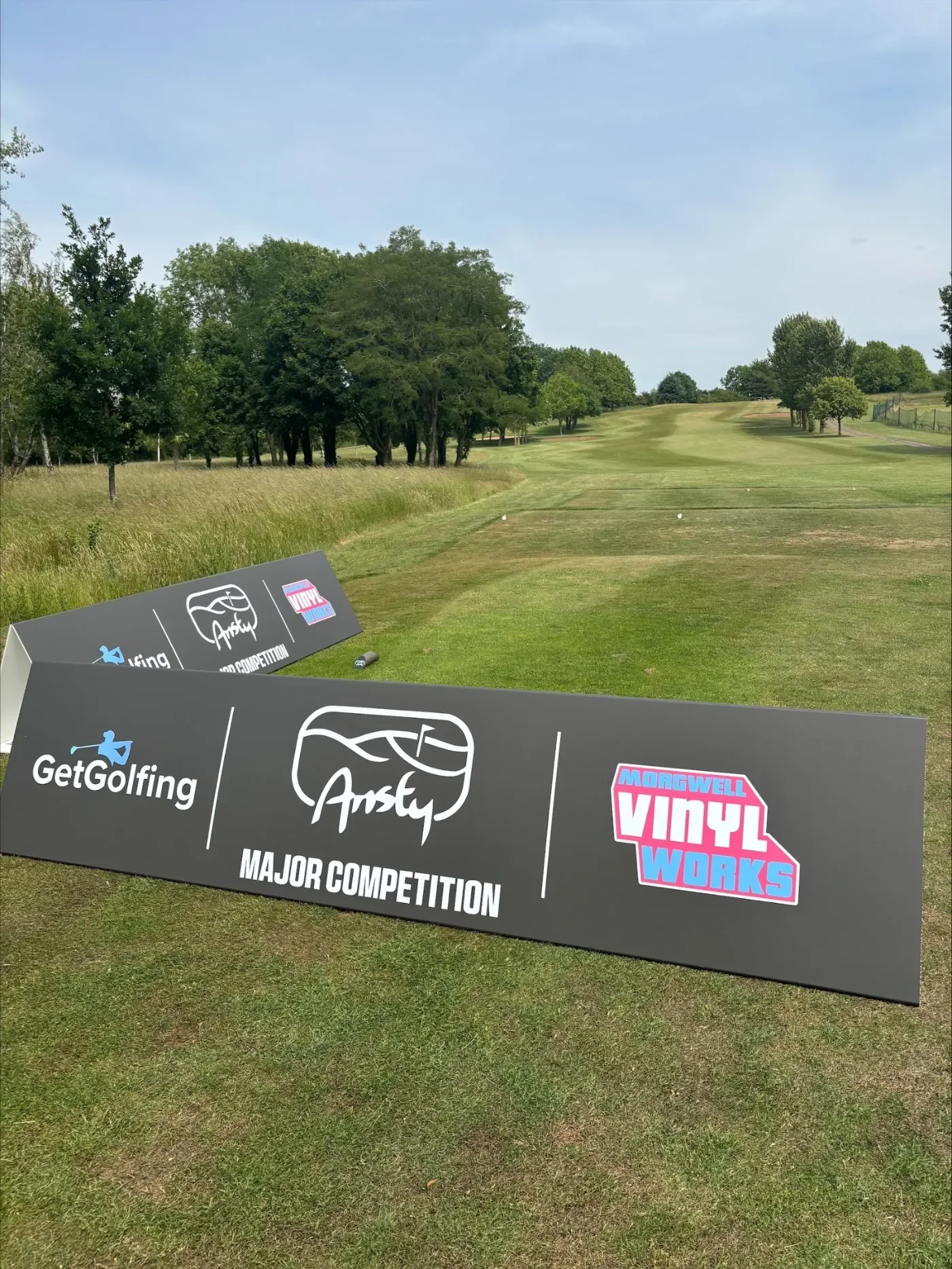 Golf tournament sponsor signs surrounding tee box