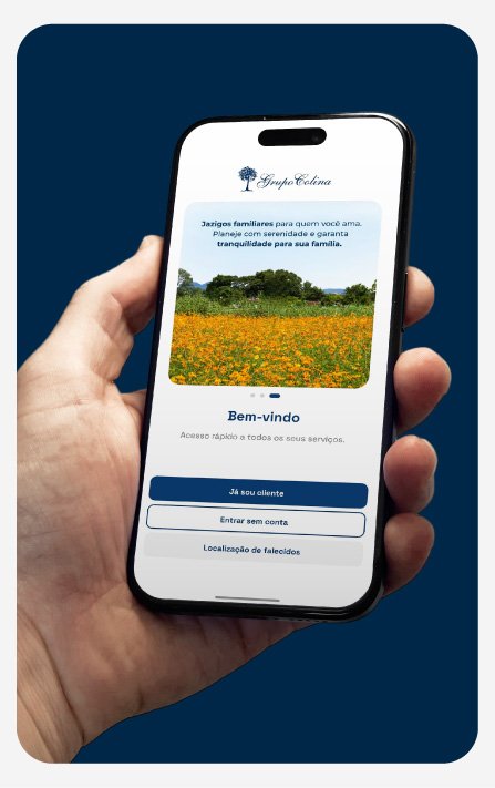 Pessoa segurando um smartphone mostrando a tela de um aplicativo com fundo azul, contendo uma imagem de campo de flores amarelas e árvores, com opções de login.