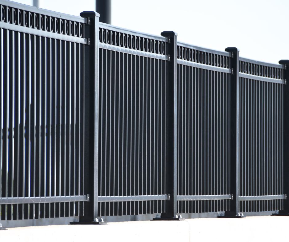 Black metal fence with vertical bars and decorative top rail
