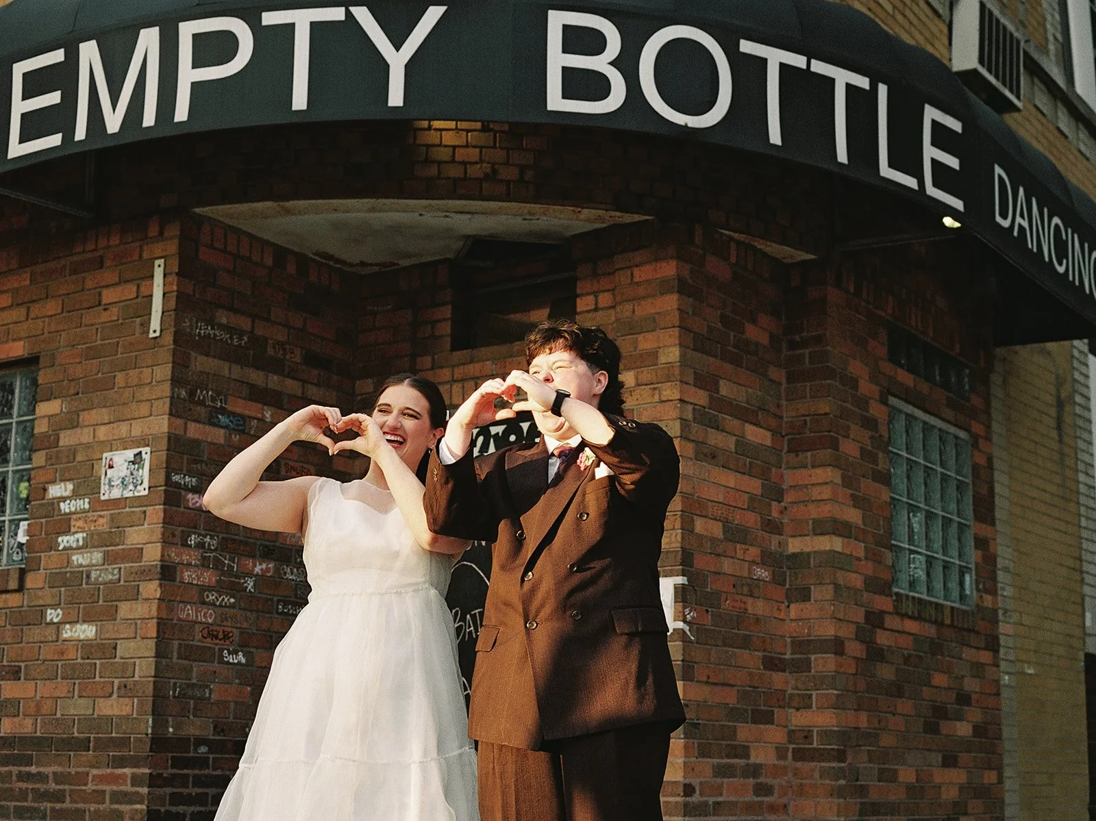 Queer couple gets married in Chicago at the empty bottle with creative, lively wedding focused on community, family, laughter. Documentary and candid photos on analog nostalgic film. Weddings by Grace is a Chicago lesbian queer luxury wedding photogr