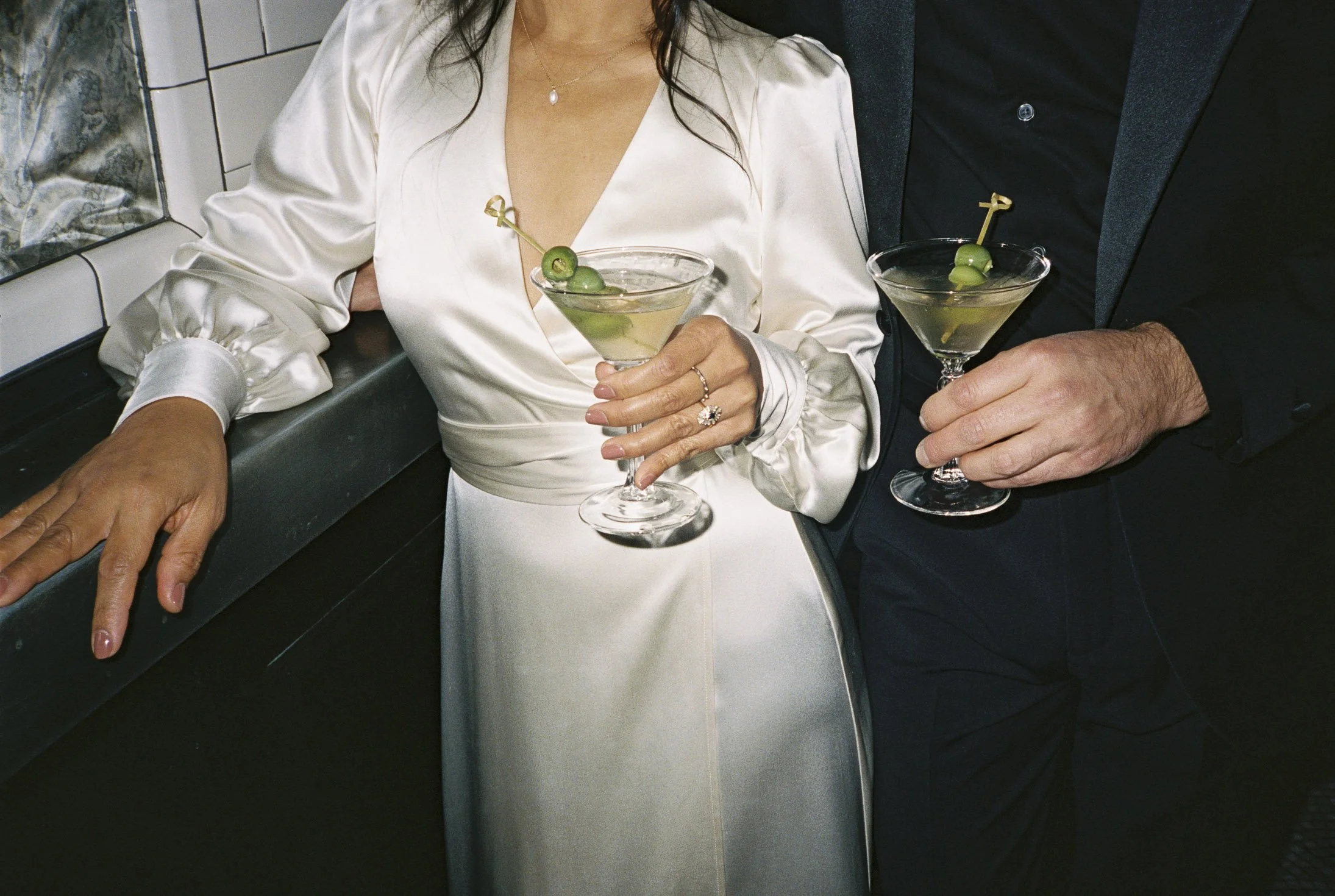 Elopement after party downtown with martini glasses in hand. Weddings by Grace is a Chicago lesbian photographer specializing in portraits, candid, editorial, documentary, events, + weddings. Analog film wedding photography, queer-owned.