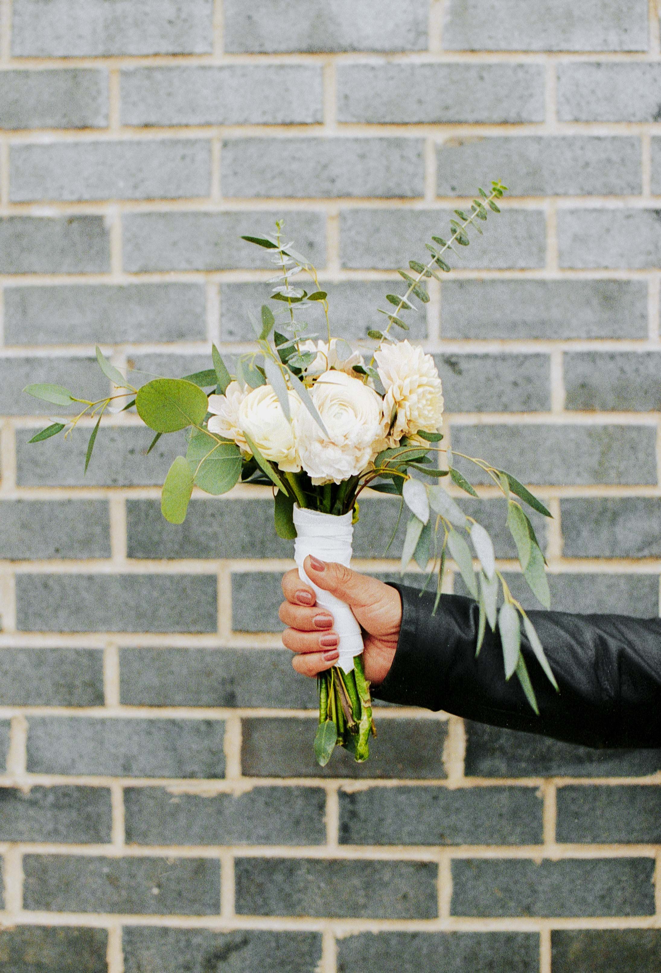 bride and groom elopement portrait of bouquet downtown chicago on film. Grace Coudal is a Chicago lesbian photographer specializing in portraits, candid, editorial, documentary, events, + weddings. Analog film wedding photography, queer-owned.