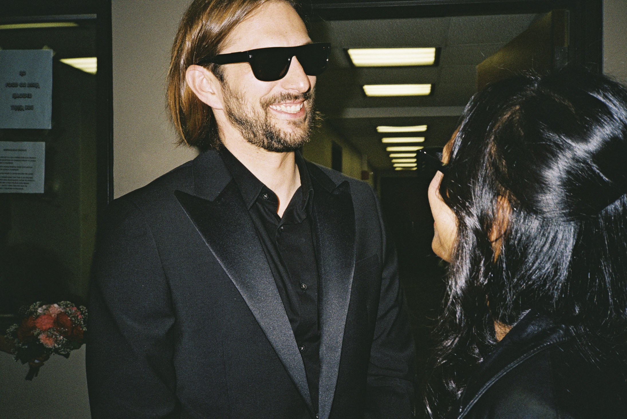 Groom candid laughing with suit and sunglasses flash film photo. City Hall Elopement in downtown chicago on film. Grace Coudal is a Chicago lesbian photographer specializing in portraits, candid, editorial, documentary, events, + weddings. Analog fil