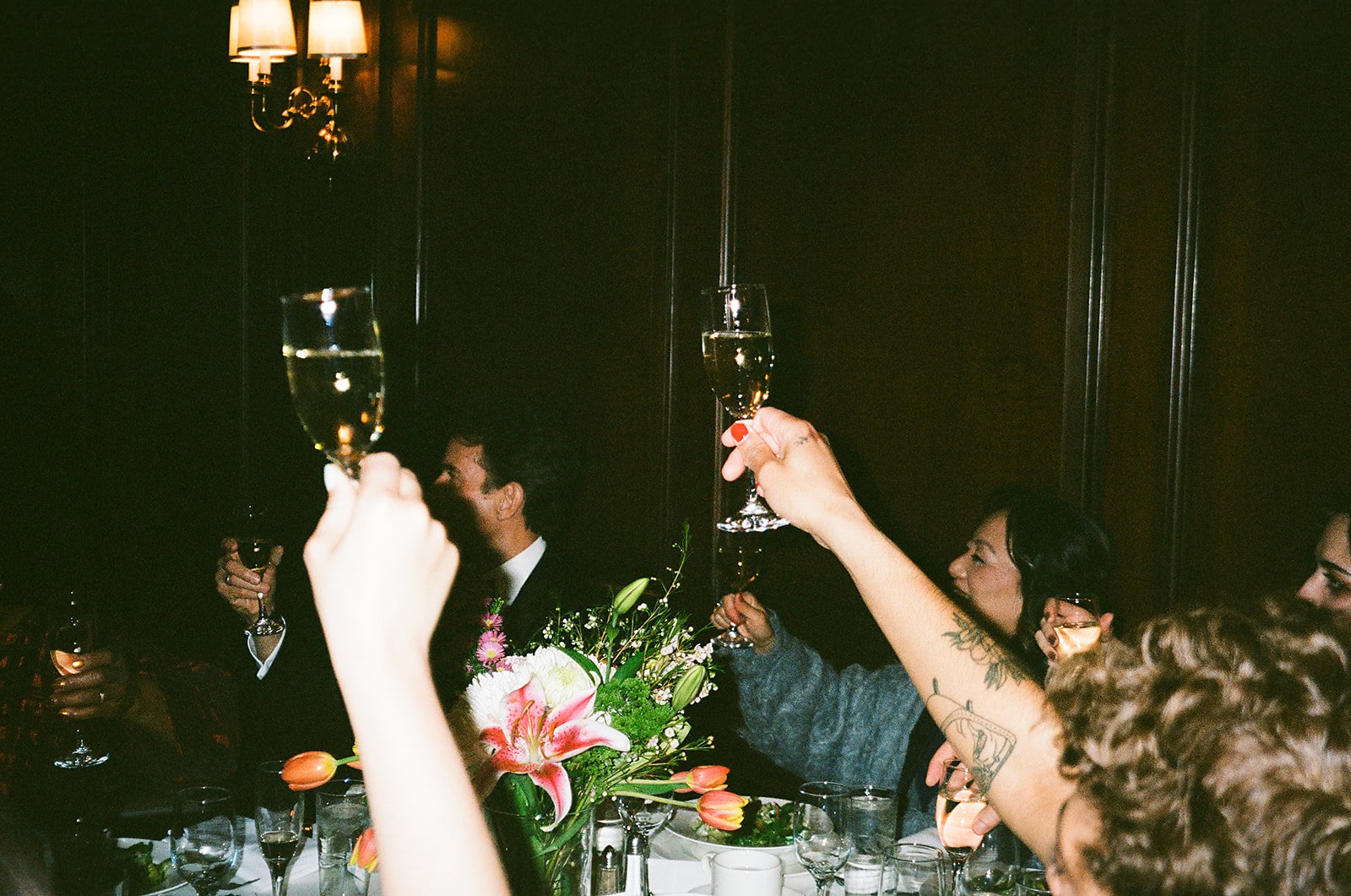 candid ambient light of cheersing. Bride and Groom marry at Lincoln Park Conservatory and Salvatores. Grace Coudal is a Chicago lesbian photographer specializing in portraits, candid, editorial, documentary, events, + weddings. Analog film wedding ph