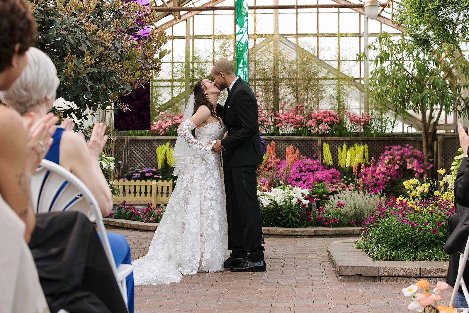first kiss at wedding ceremony. Bride and Groom get married at Lincoln Park Conservatory and Salvatores. Grace Coudal is a Chicago lesbian photographer specializing in portraits, candid, editorial, documentary, events, + weddings. Analog film wedding