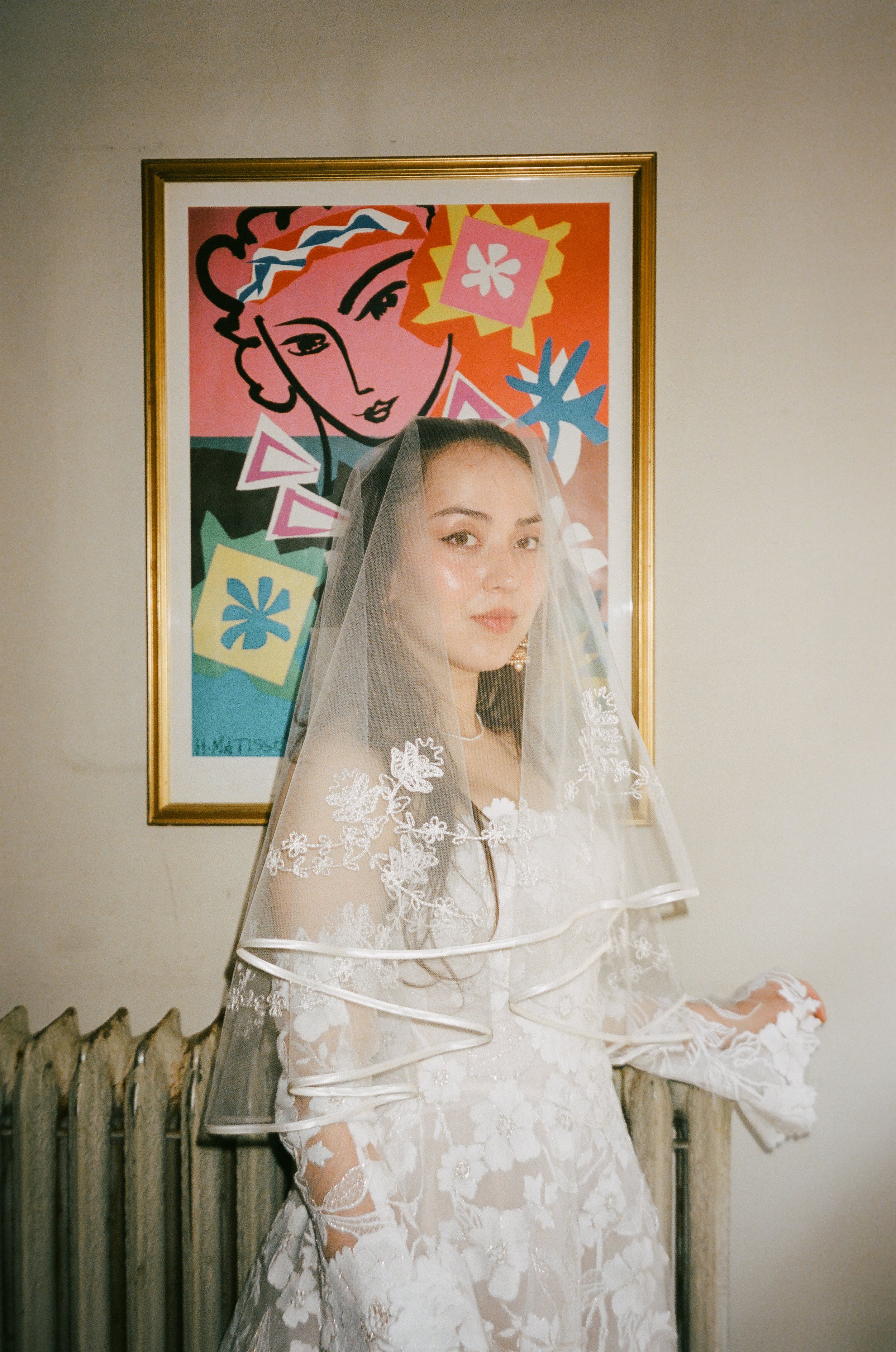 film portrait of mary in front of art work at her childhood home. Bride and Groom get married at Lincoln Park Conservatory and Salvatores. Grace Coudal is a Chicago lesbian photographer specializing in portraits, candid, editorial, documentary, event