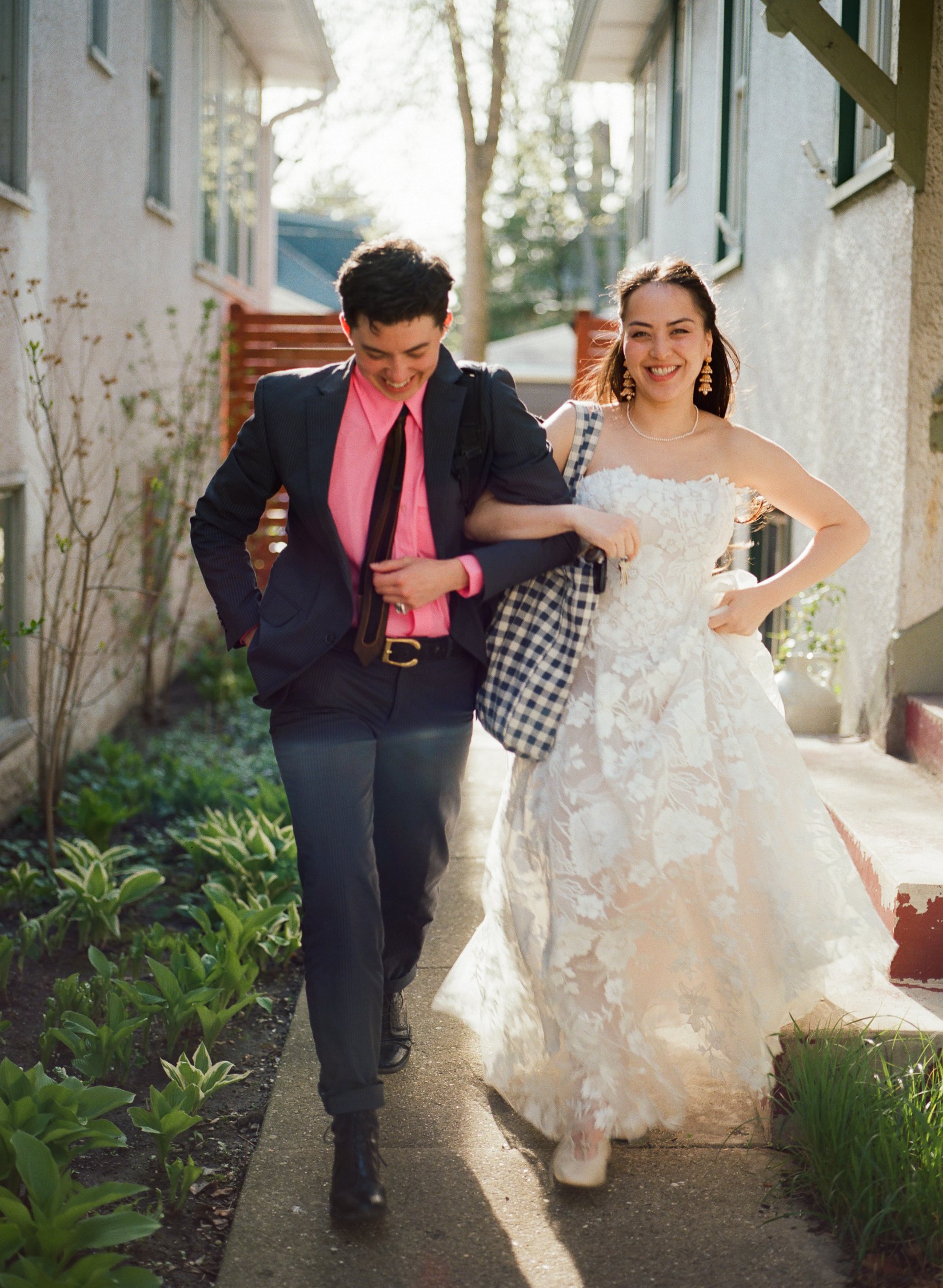 bride and best friend smile as leaving getting ready house to go to ceremony. Bride and Groom get married at Lincoln Park Conservatory and Salvatores. Grace Coudal is a Chicago lesbian photographer specializing in portraits, candid, editorial, docume
