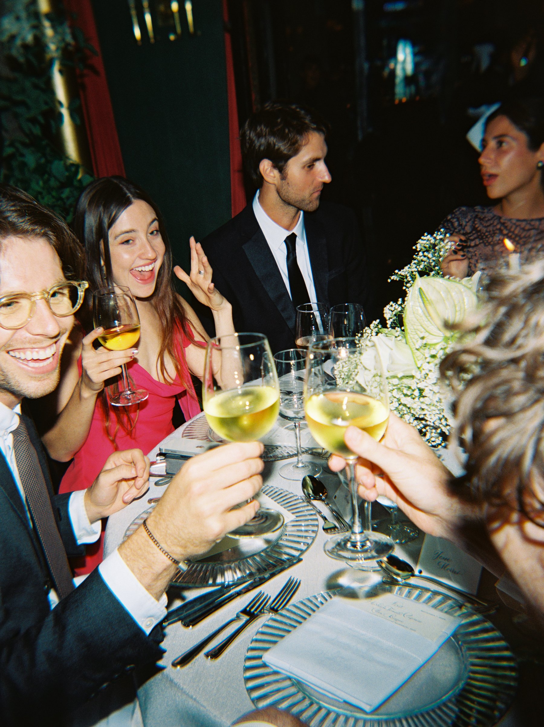 film photo of guests cheersing at wedding. Grace Coudal is a Chicago lesbian photographer specializing in portraits, product, food, lifestyle, events, + weddings. Analog film photography, queer-owned.