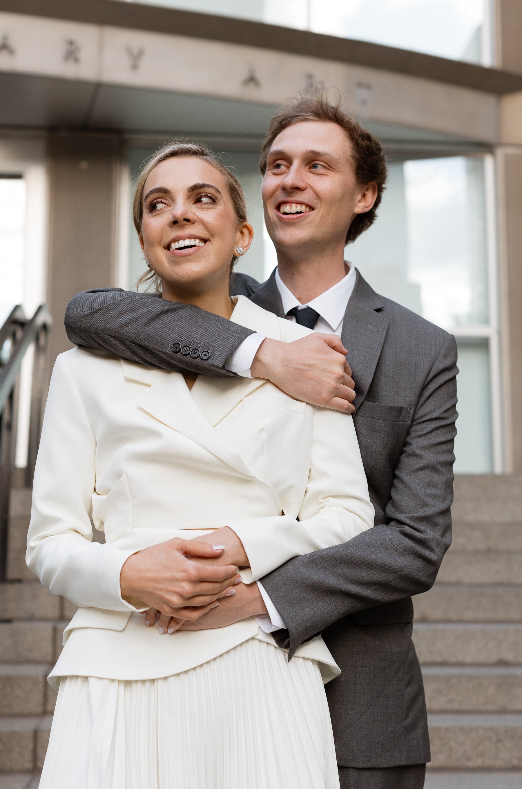 bride and groom at rehearsal dinner stand on steps of MCA chicago museum. Grace Coudal is a Chicago lesbian photographer specializing in portraits, product, food, lifestyle, events, + weddings. Analog film photography, queer-owned.