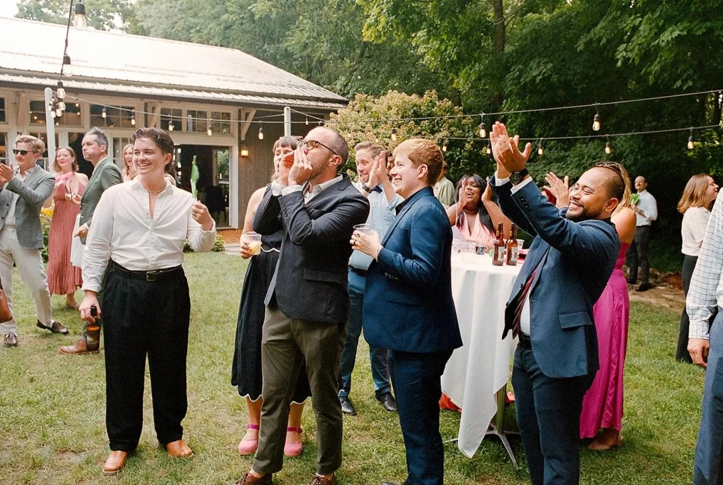 Fun film photo of guests at backyard outdoor wedding in michigan during cocktail hour. Luxury, high-end wedding photographer shot on film. Weddings by Grace, Chicago photographer specializing in portraits, candid, editorial, documentary, events, + we