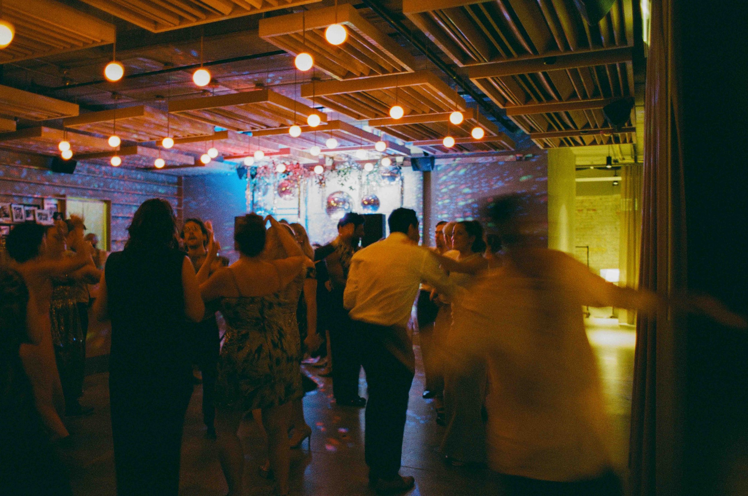 Groom and groom get married at maxwells trading with creative, lively wedding focused on community, queer family, laughter. Documentary and candid photos on analog nostalgic film. Weddings by Grace is a Chicago lesbian queer luxury wedding photograph