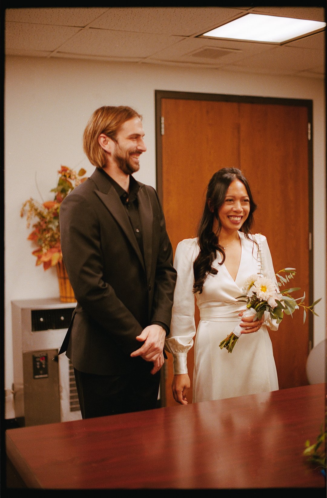 Bride and groom stand at City Hall Elopement in downtown chicago to get married on film. Grace Coudal is a Chicago lesbian photographer specializing in portraits, candid, editorial, documentary, events, + weddings. Analog film wedding photography, qu