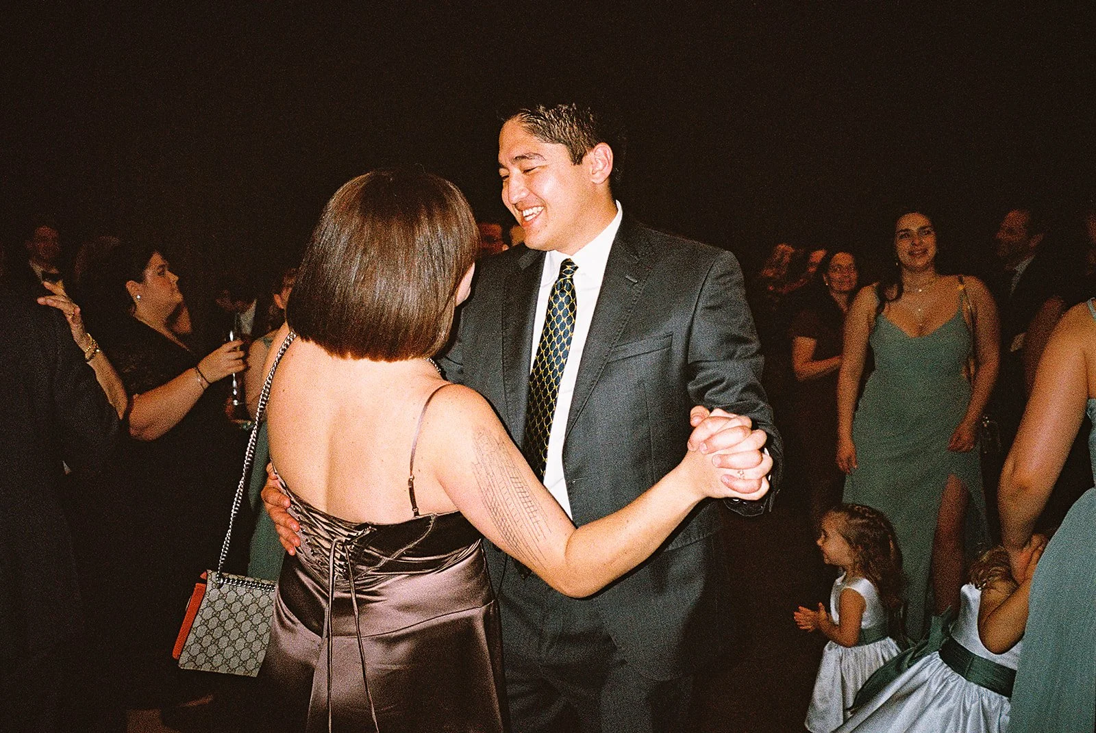 Bride and groom get married in Chicago at WildmanBT, with creative, lively wedding focused on community, family, laughter. Documentary and candid photos on flash film. Weddings by Grace is a Chicago lesbian queer luxury wedding photographer specializ