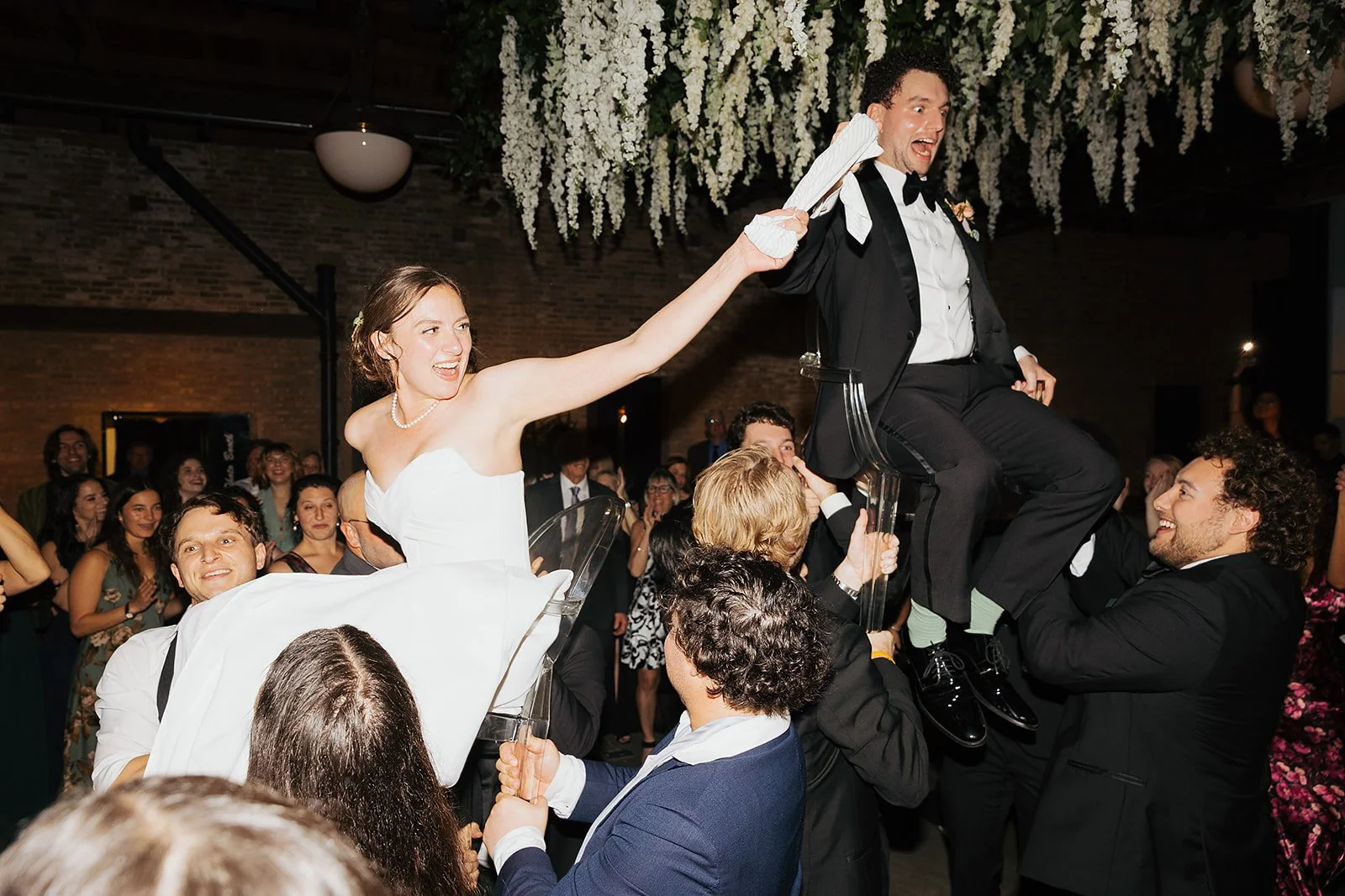 Bride and groom get married in Chicago at WildmanBT, with creative, lively wedding focused on community, family, laughter. Documentary and candid photos on flash film. Weddings by Grace is a Chicago lesbian queer luxury wedding photographer specializ