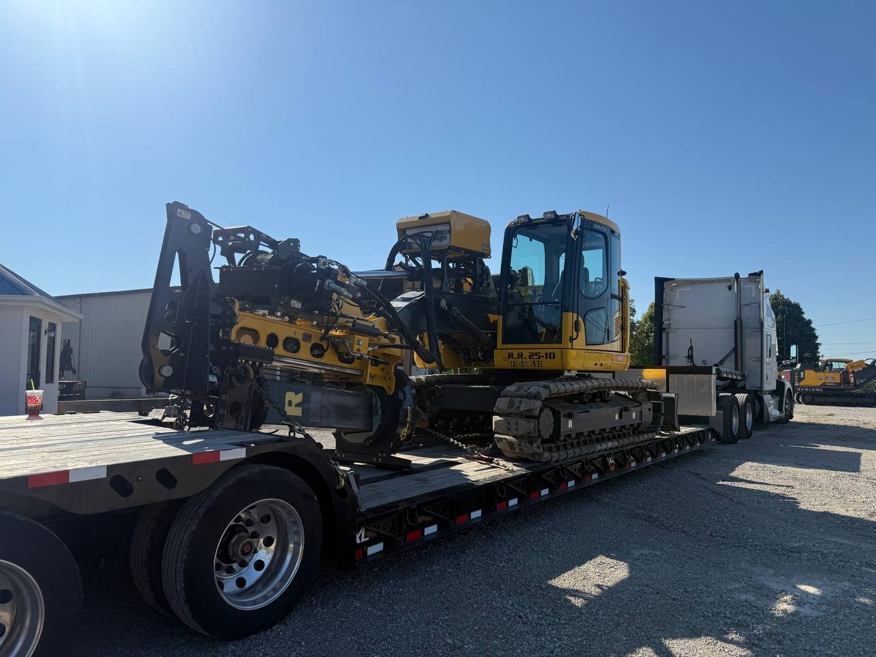 A large yellow and black bulldozer loaded onto a flatbed truck