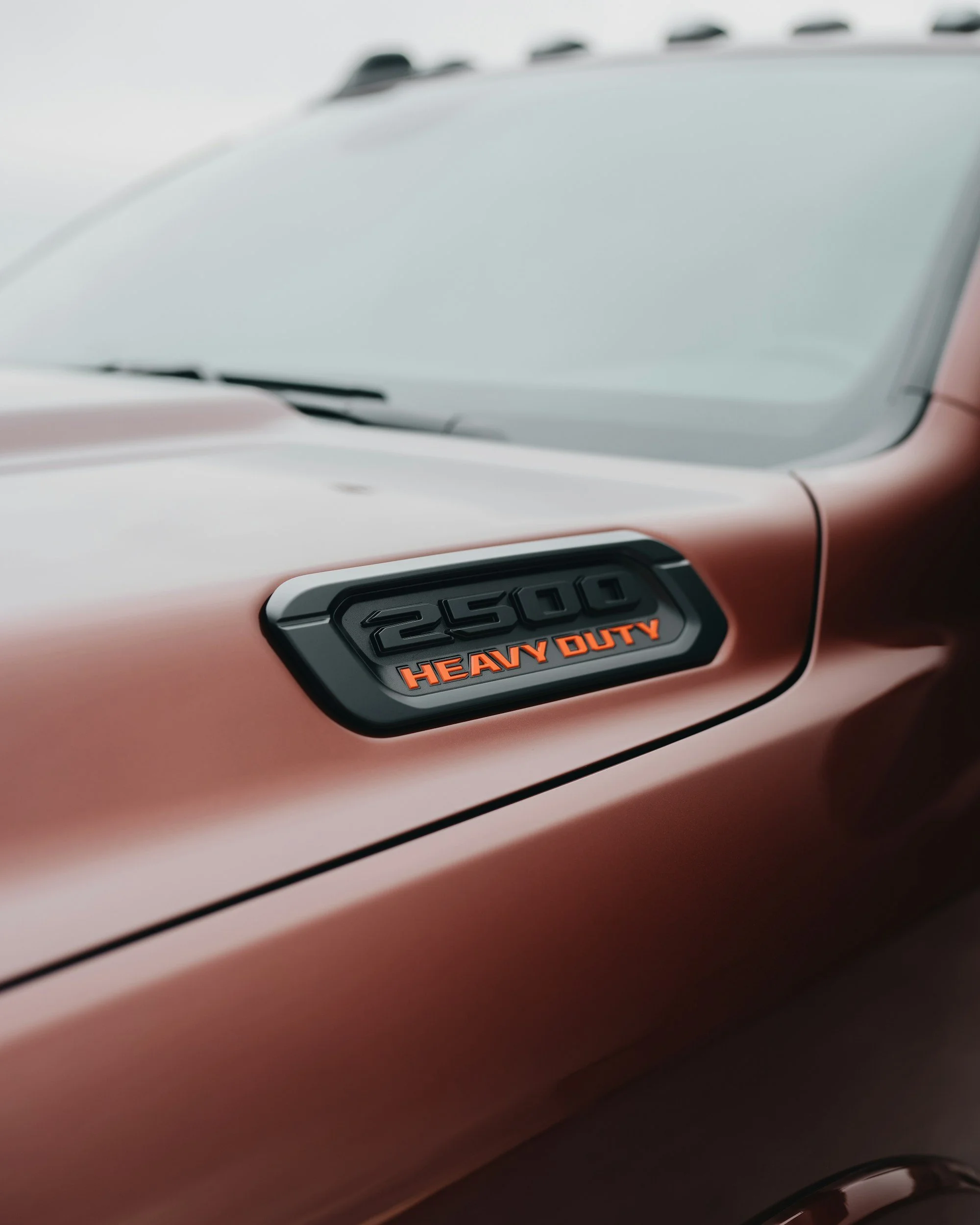 Close-up of a vehicle's front hood with a badge that has '2500 Heavy Duty' written on it.