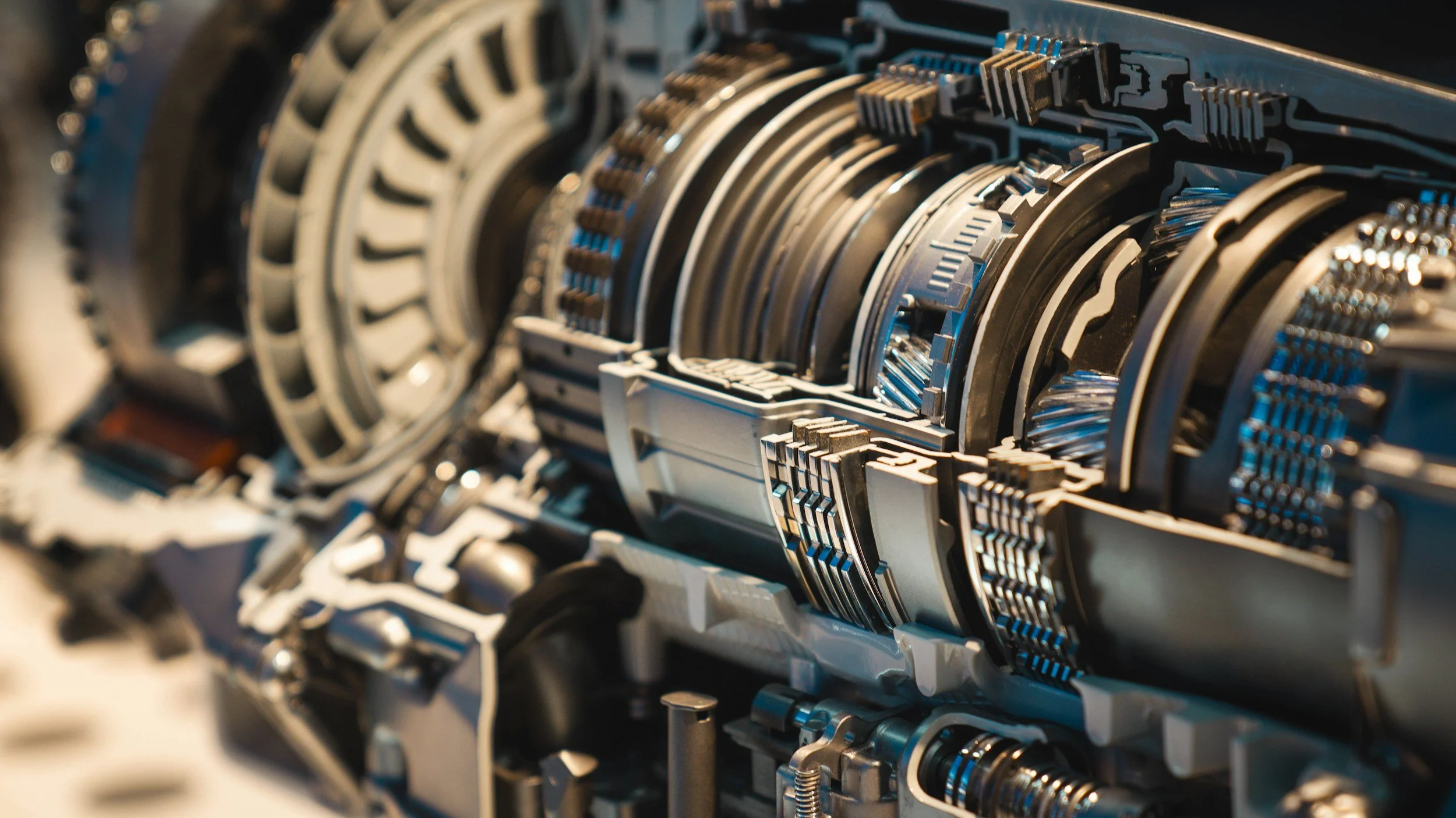 Close-up of intricate mechanical components with metallic and blue accents, likely part of a complex machine or engine.