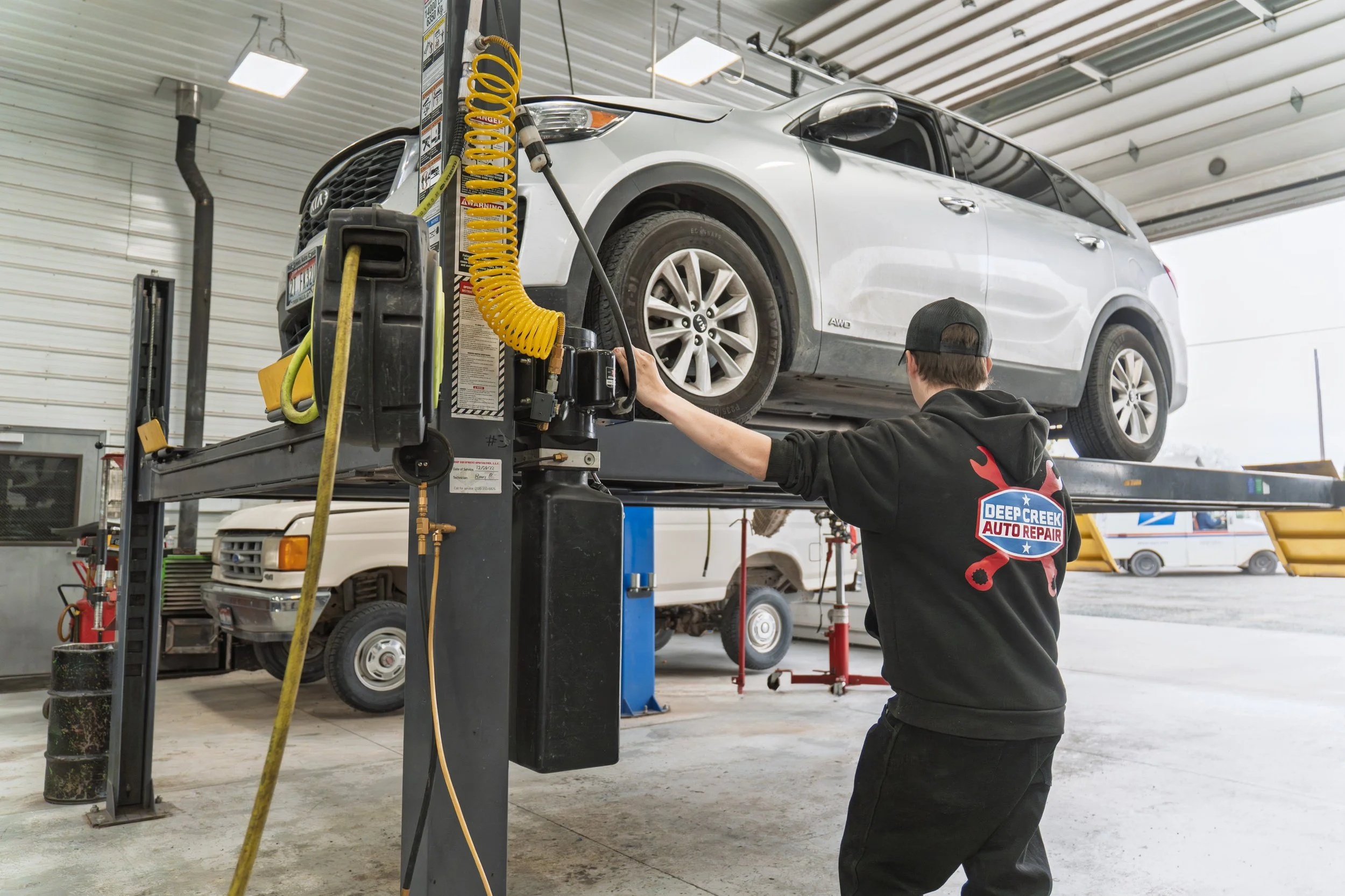 Car on lifts being repaired by auto mechanic in garage