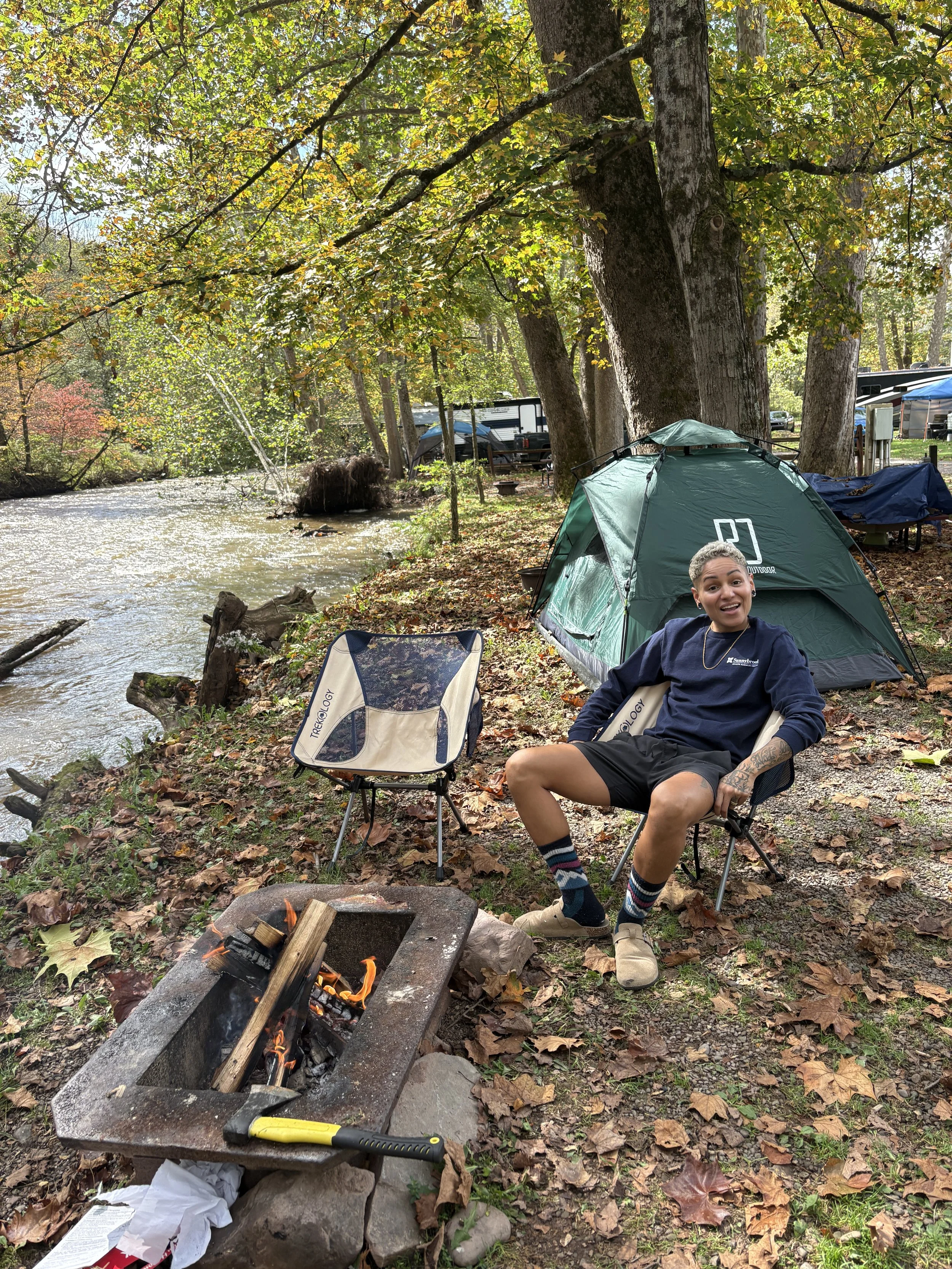 Camping is one of my happy places (E at a campsite sitting in front of the fire)