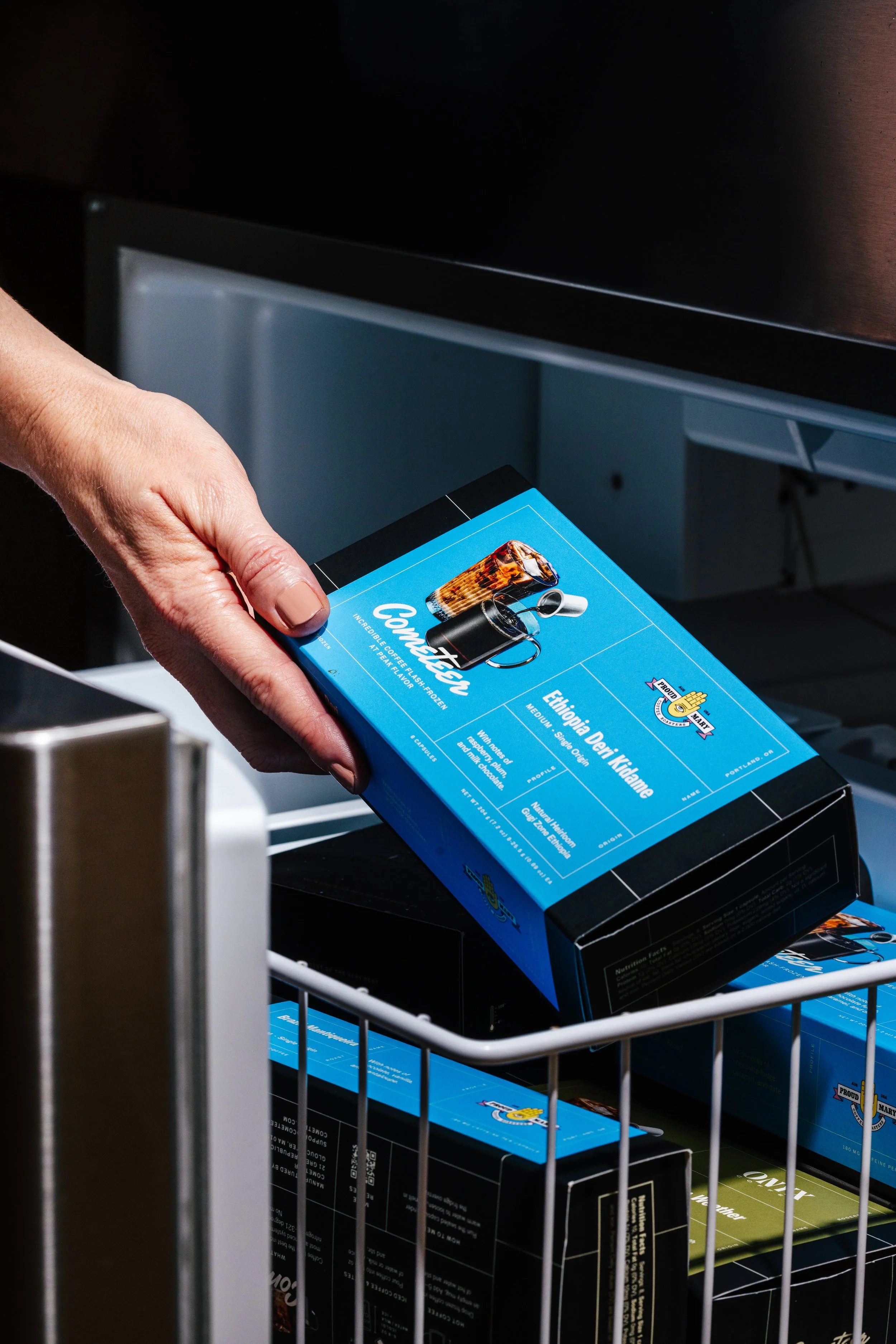 A person holding a blue packaged coffee product on a photo shoot for CPG product photography to increase sales 