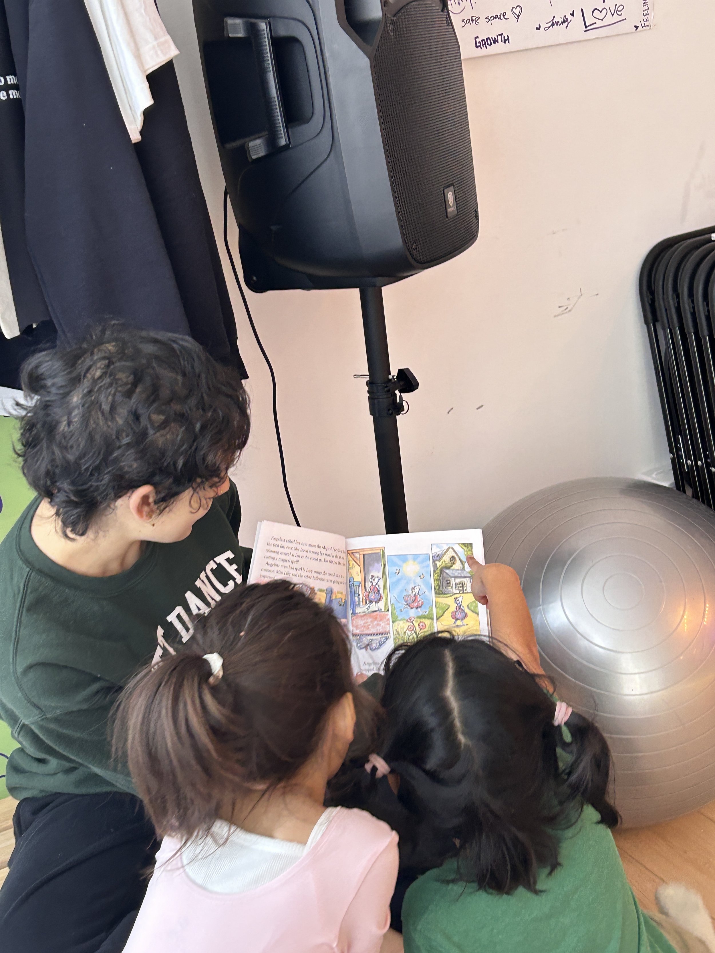 Instructor reading a picture book with children during a storytime activity at ESTIA House of Movement.