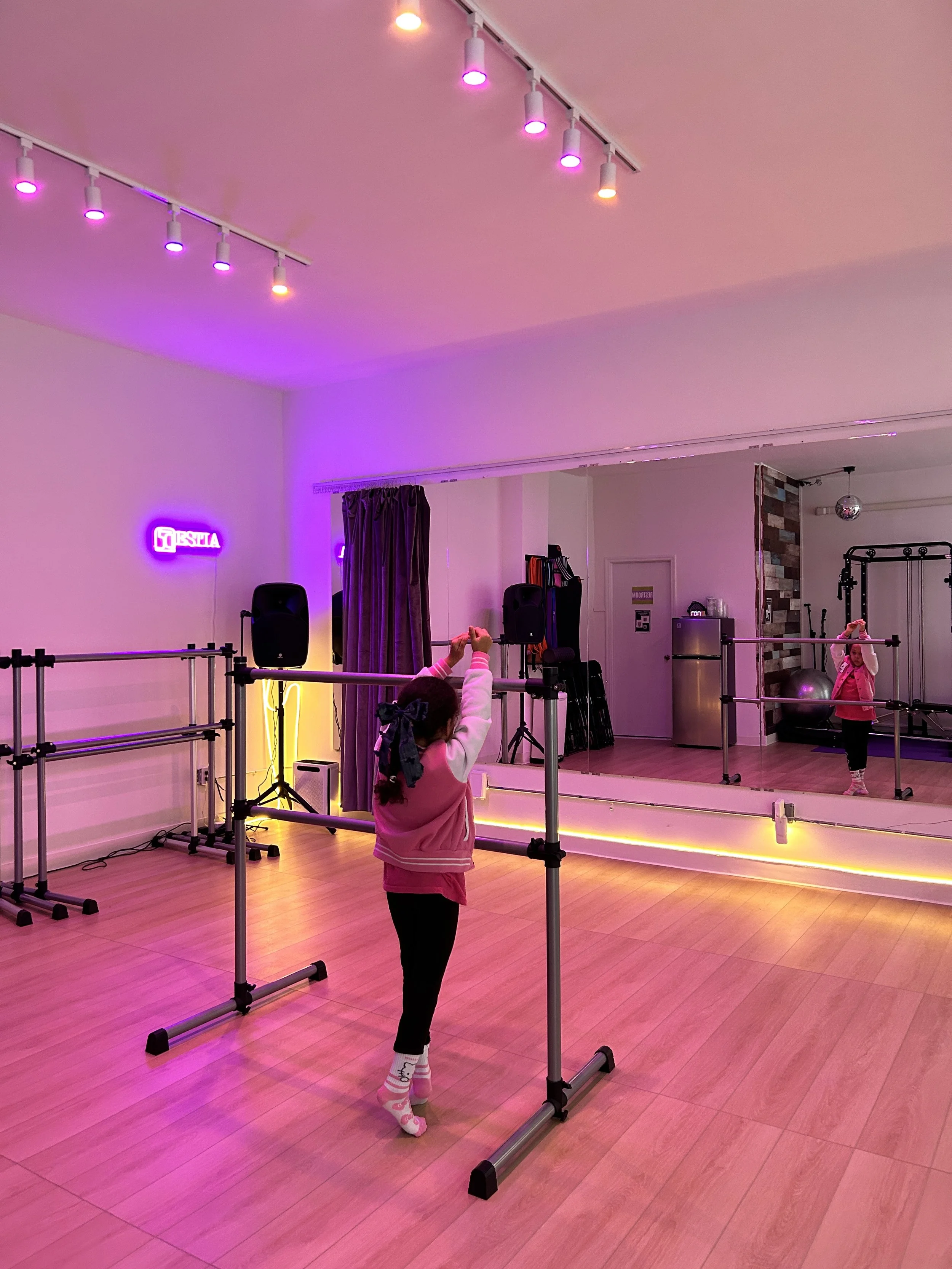 Child practicing ballet at the barre during a dance class at ESTIA House of Movement.