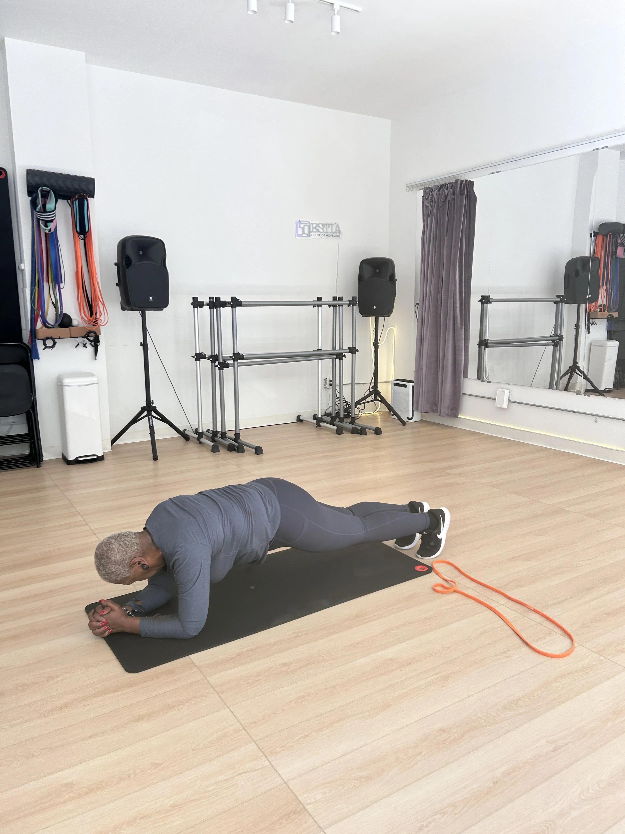 Woman performing a plank exercise on a floor mat during a personal training session at ESTIA House of Movement.