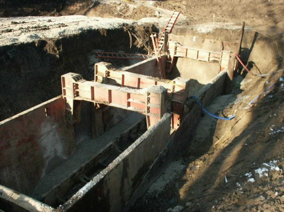 Underground construction site with wooden and metal supports in a deep excavation.