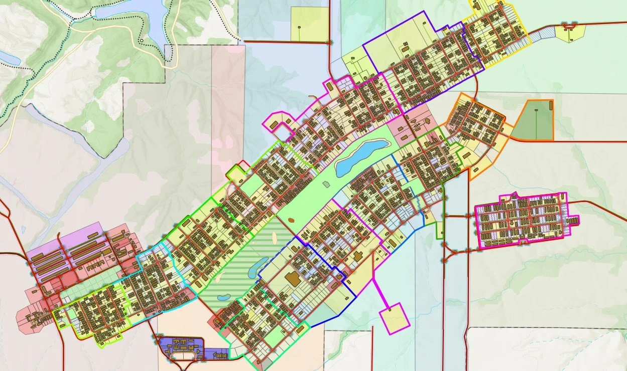 Map showing a planned community or city layout with colored zones, roads, a lake, and green spaces.