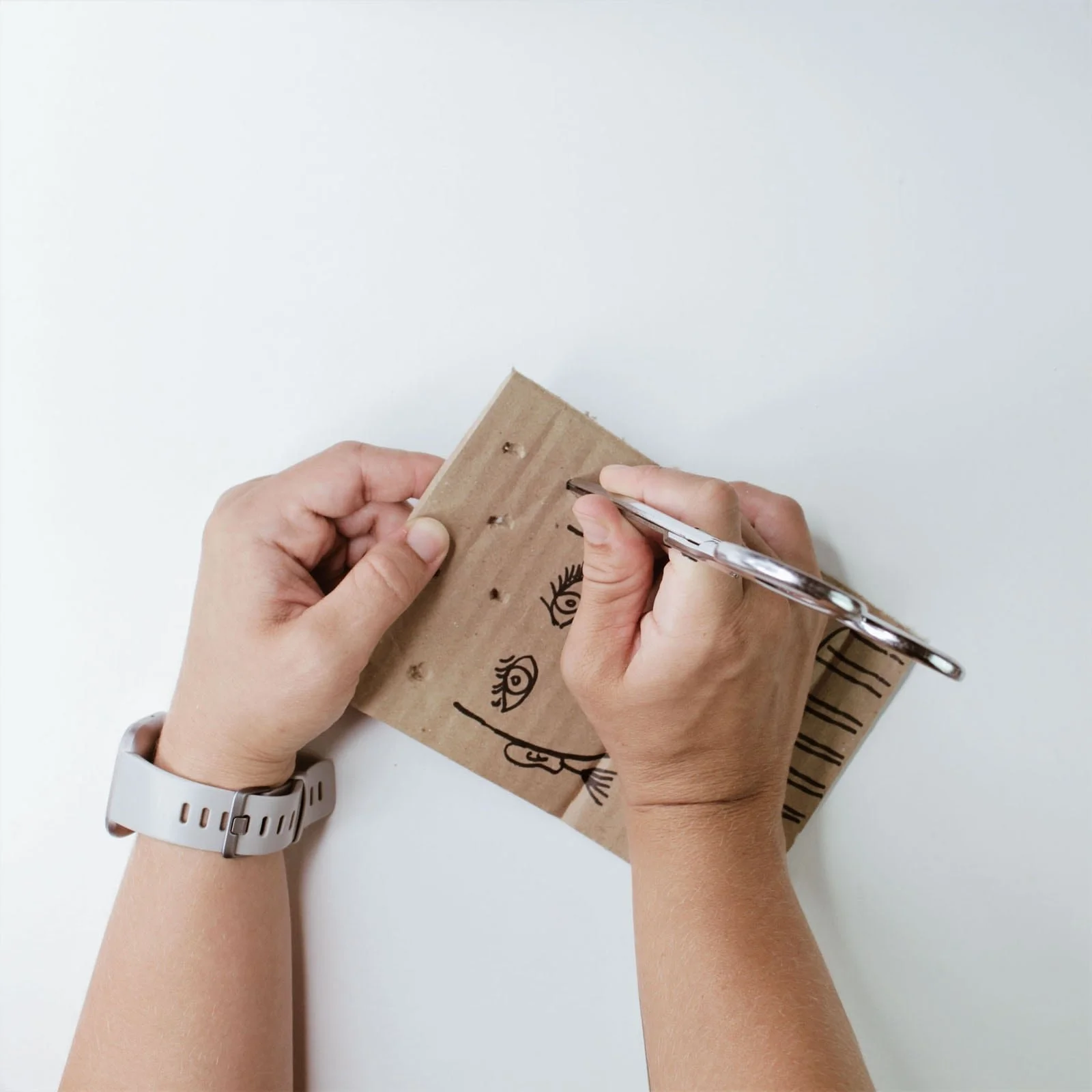 Poking holes in cardboard for nature portrait threading board