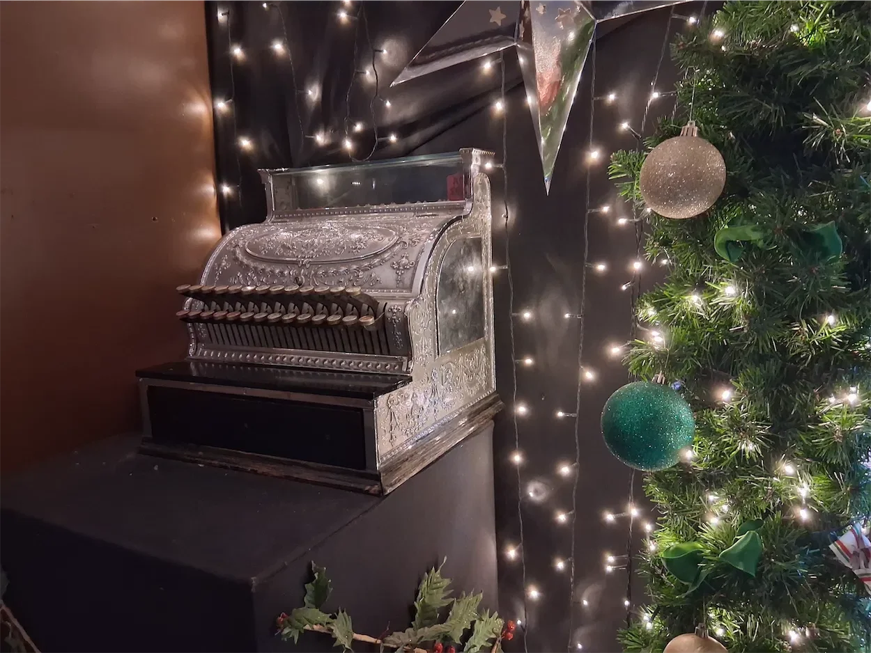 A view of the Santa set at Willow Activity Farm with numerous Xmas trees, an old style cash register and lights