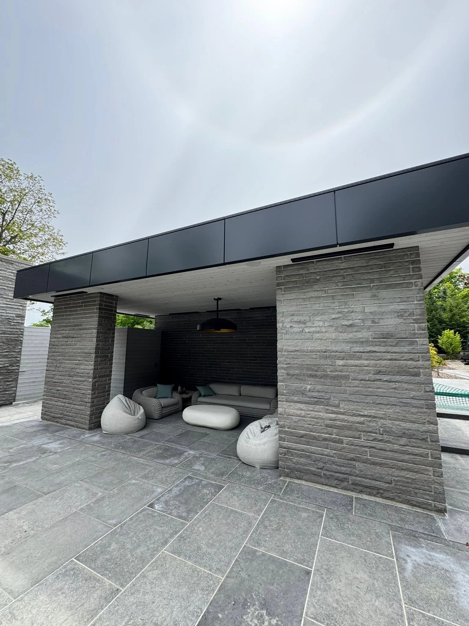 Modern outdoor lounge featuring Ottawa Platinum limestone paving and cladding, with sleek architectural pillars and a luxury residential patio design