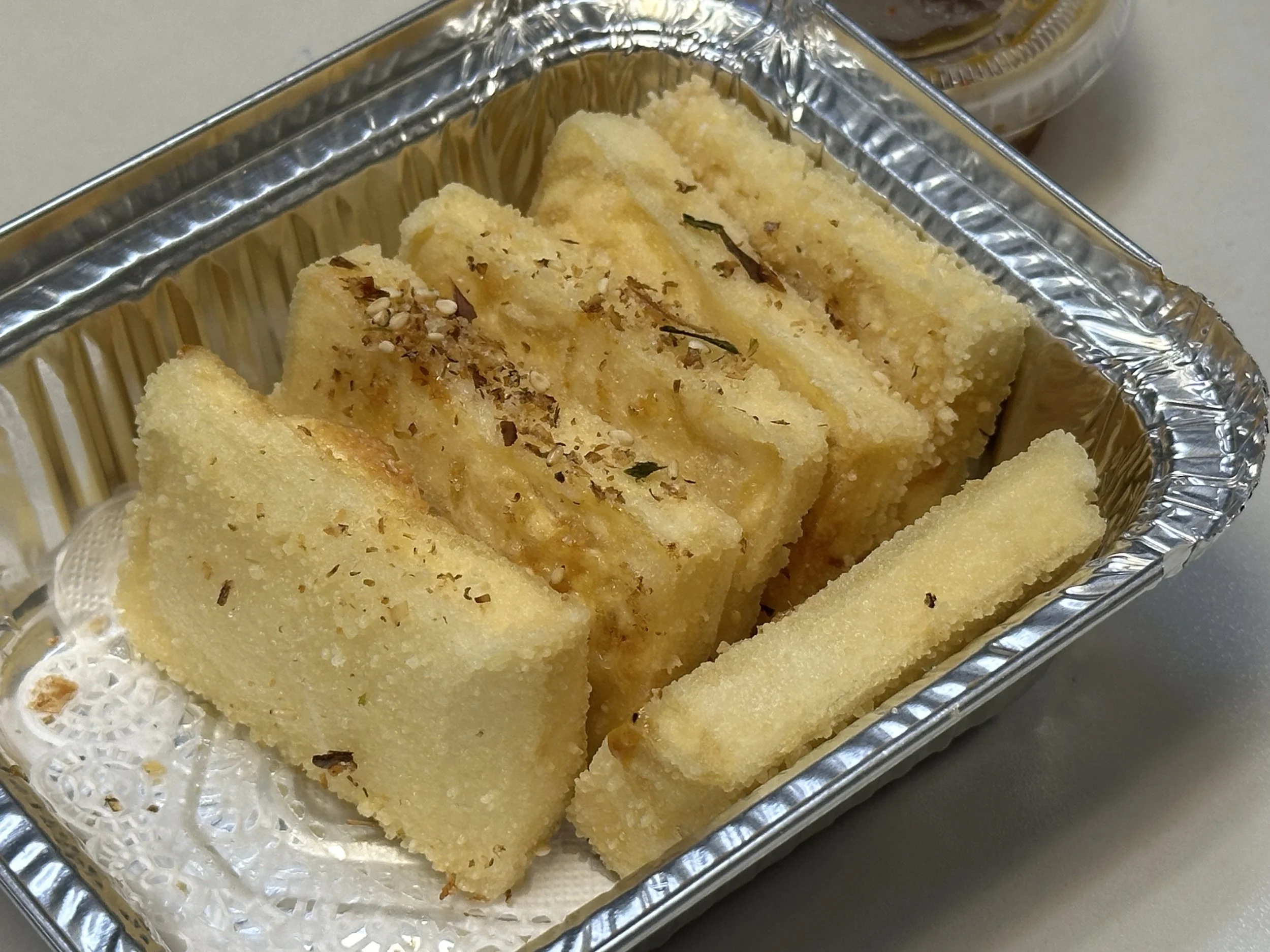Slices of yellow cornbread, garnished with herbs.