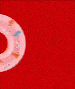 Close-up of a red and white circular object with multicolored symbols or icons on a red background.