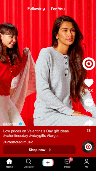 Two young women, one in a red sweater and the other in a gray sweatshirt, sitting in front of a red curtain, with one smiling and the other looking to the side. The image appears to be a TikTok video screenshot.