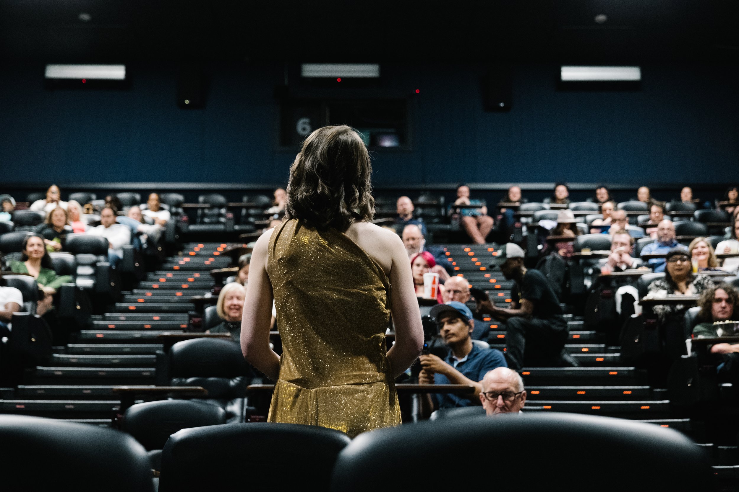 Photograph of Courtney Mentzel in a golden outfit in front of a crowd at the 2024 Dallas screening of Jammingers: An Overture of Gold and Silver - Episode 1 - A Metallic Introduction
