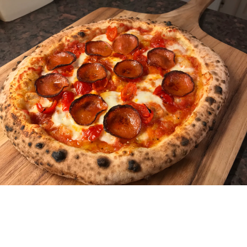 Pizza with pepperoni, tomato, cheese, and a slightly charred crust on a wooden board.